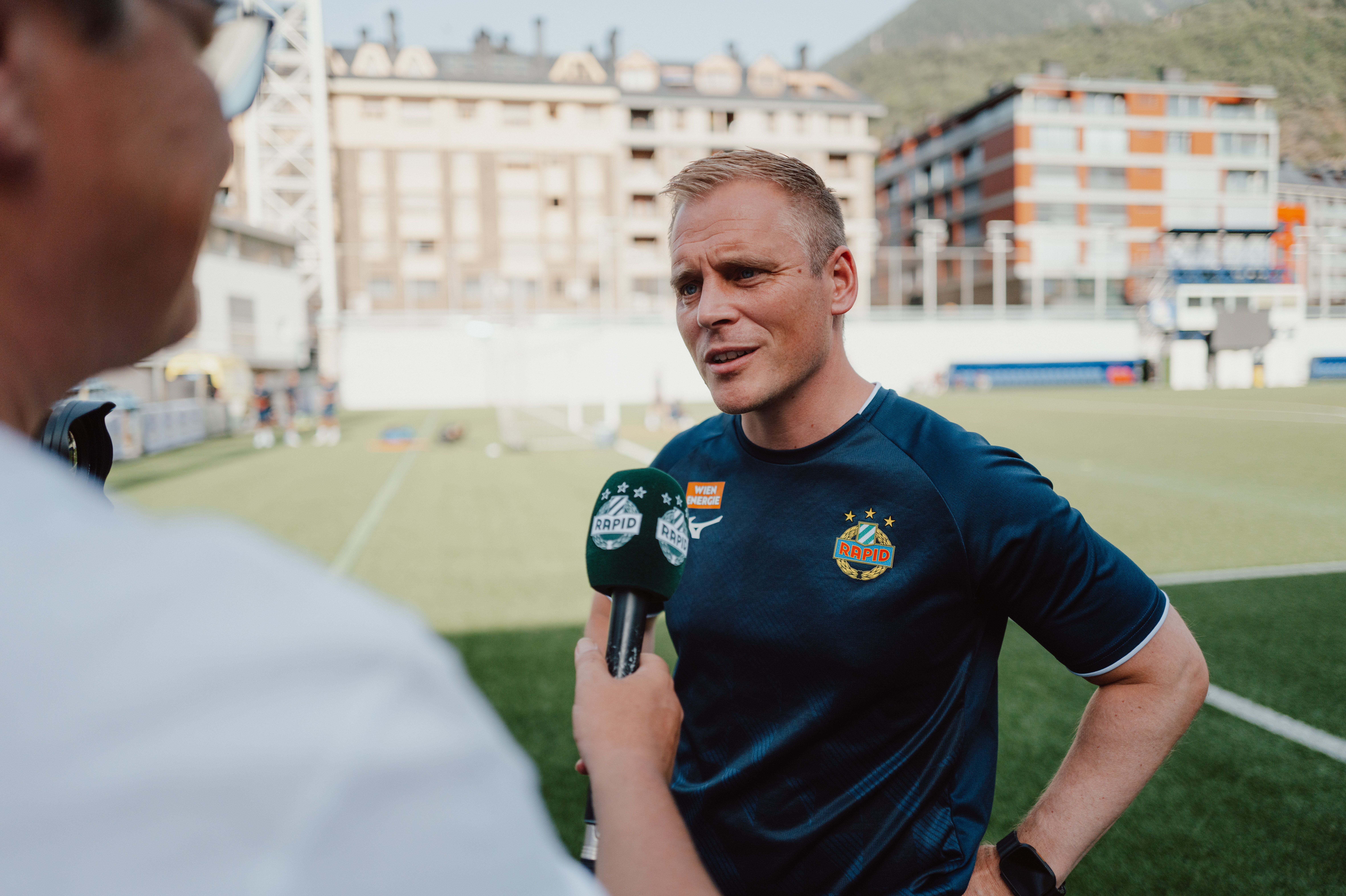 Ein Trainer von Rapid Wien gibt ein Interview auf einem Fußballplatz in Andorra.