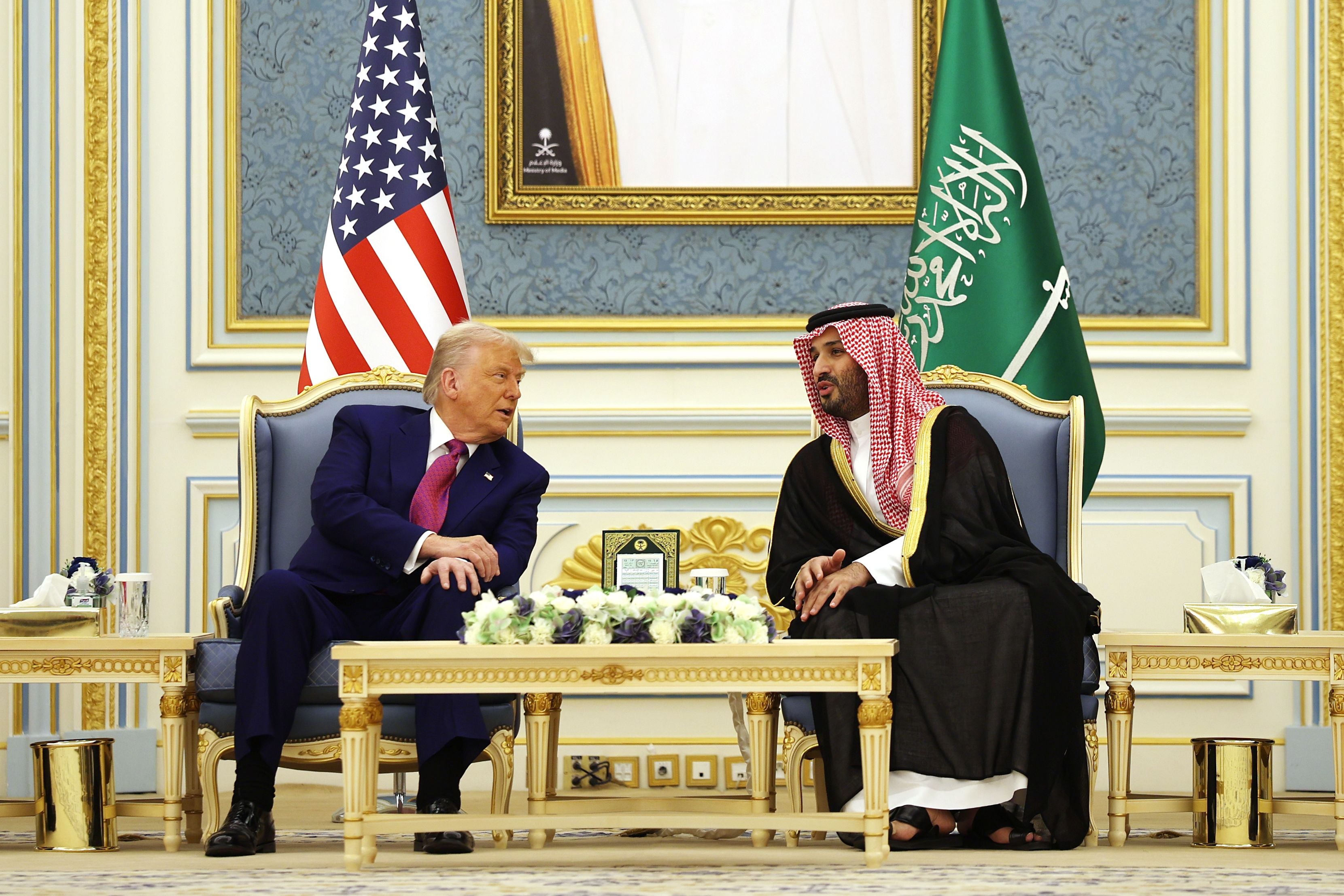 Donald Trump und Mohammed bin Salman sitzen bei einem Treffen vor US- und Saudi-Arabien-Flaggen.