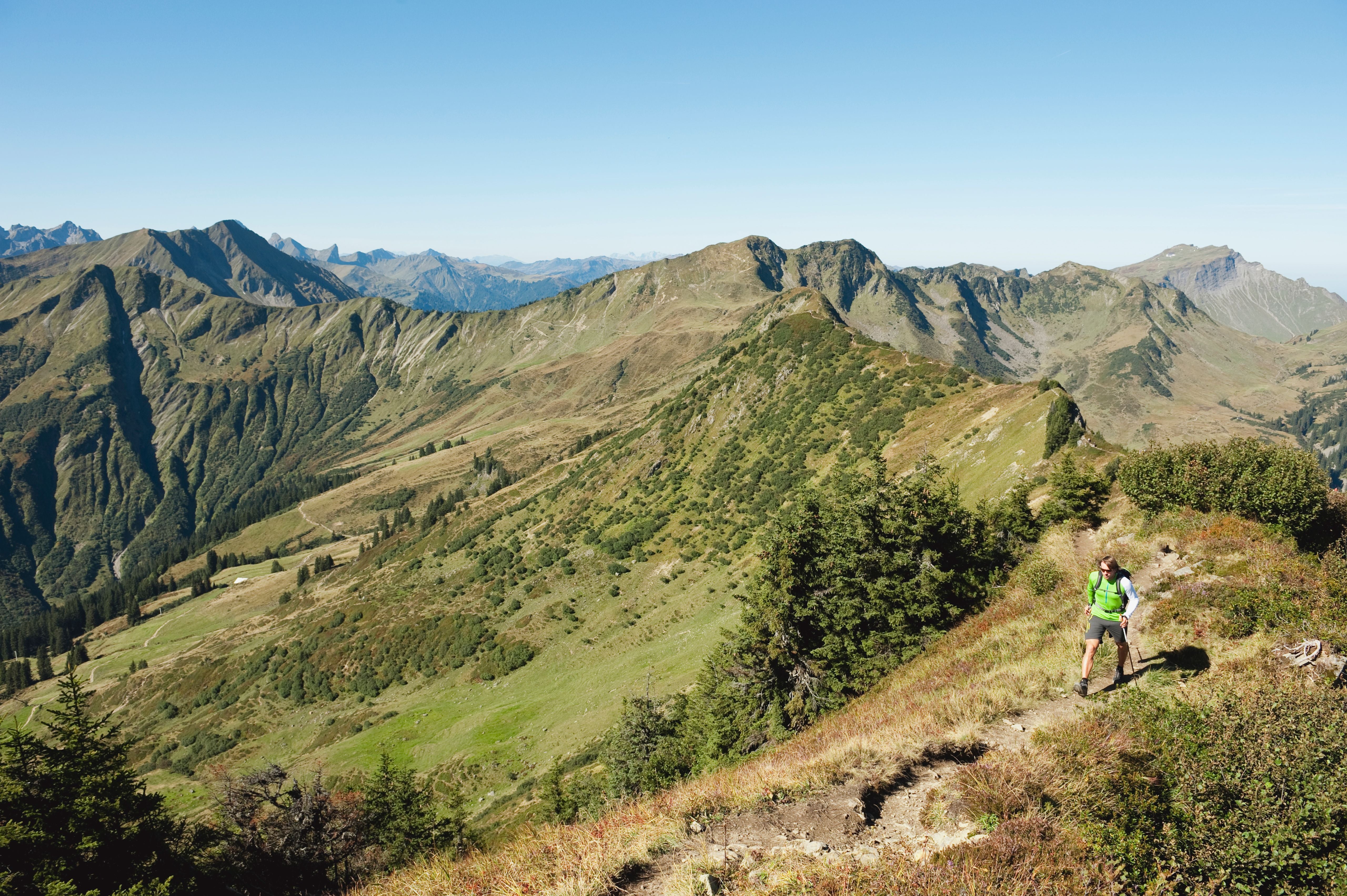 Ein Wanderer geht auf einem schmalen Bergpfad im Kleinwalsertal.