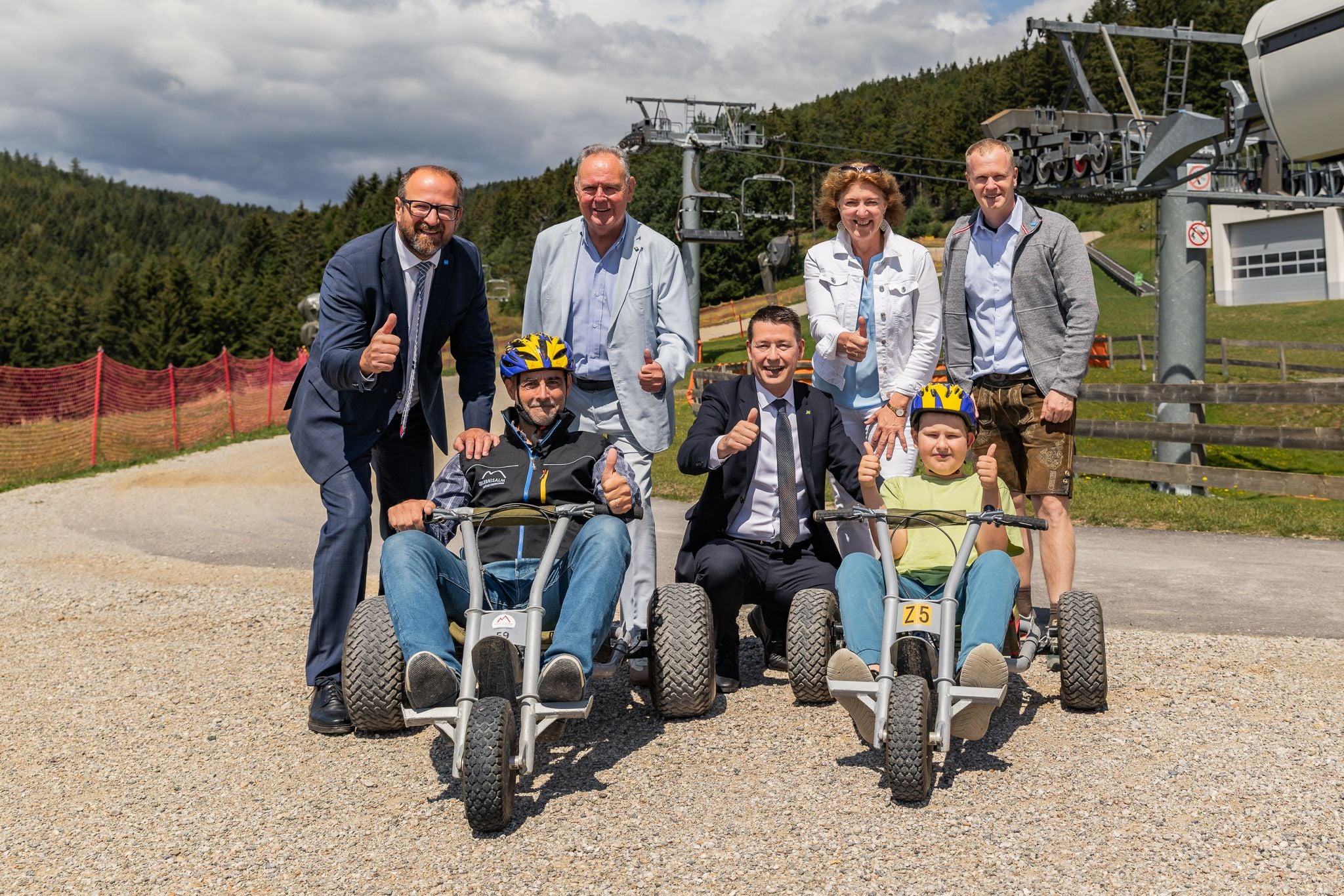 Gruppe von Menschen posiert mit Kettcars im Freien auf der Erlebnisalm Mönichkirchen.