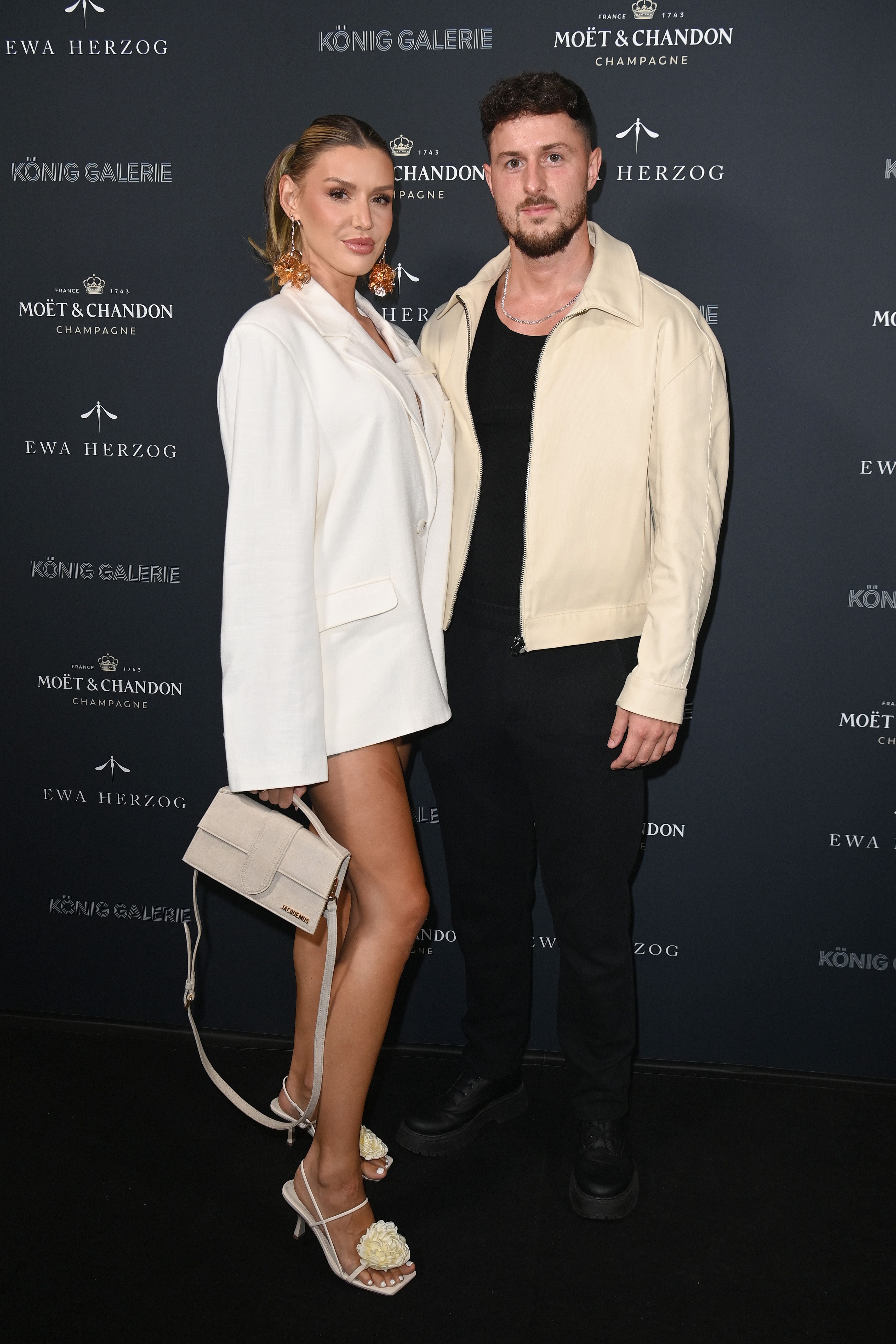 Ein schick gekleidetes Paar posiert zusammen auf dem roten Teppich bei einer Fashion Week.