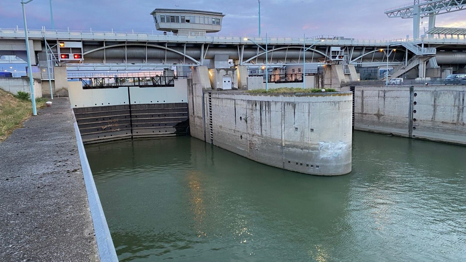Eine Schleuse an einem Fluss mit geschlossenem Schleusentor bei Abendlicht.