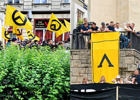 Demonstrierende Menschen mit gelben Fahnen und Bannern der Identitären Bewegung in einer Stadt.