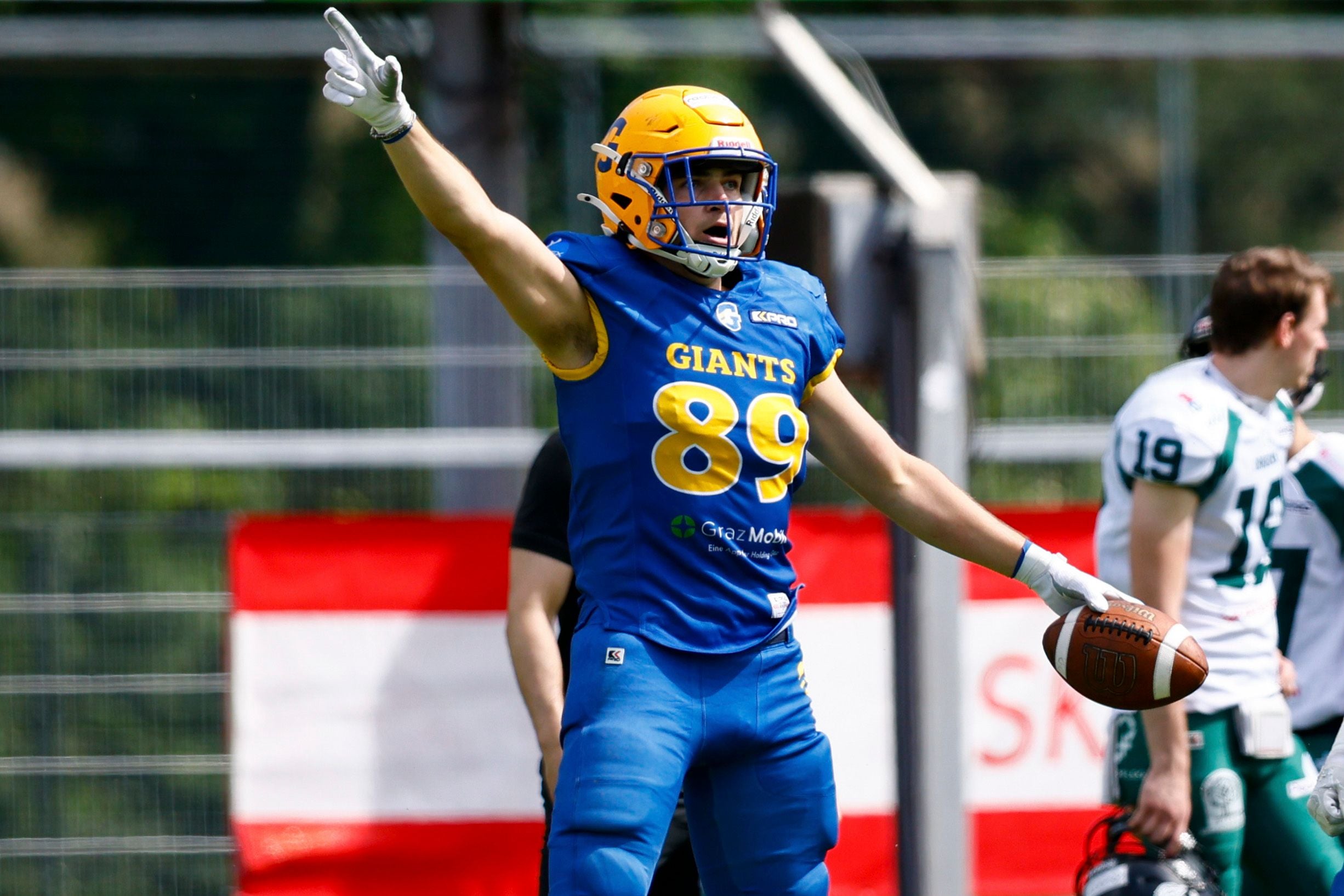 Ein Footballspieler der Graz Giants jubelt auf dem Spielfeld mit ausgestrecktem Arm und Ball in der Hand.