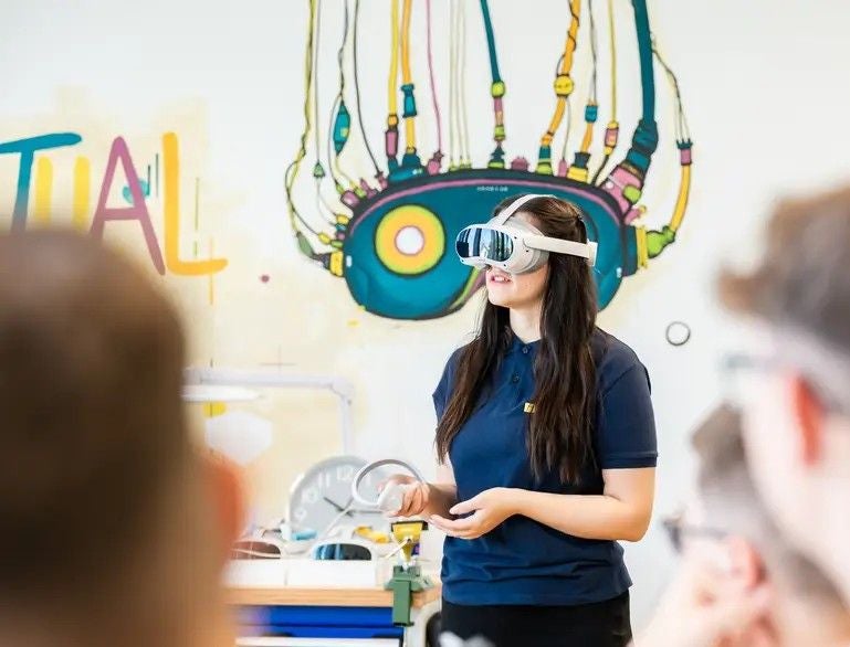 Frau mit Virtual-Reality-Brille hält Vortrag vor einer Gruppe in kreativ gestaltetem Raum.