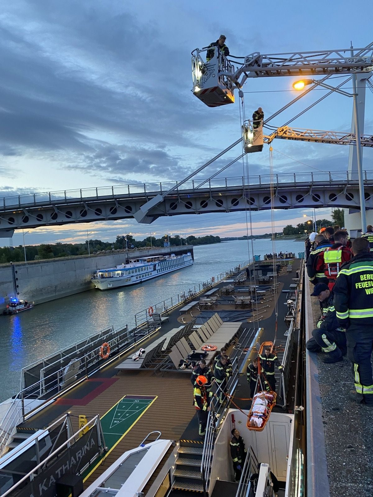 Feuerwehr rettet verletzte Person mit einer Trage von einem Flusskreuzfahrtschiff bei einer Schleuse.