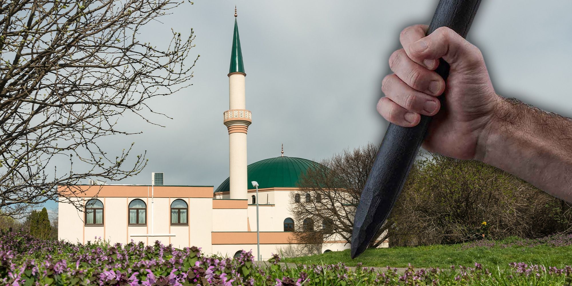 Große Hand hält einen angespitzten Holzpfahl vor einer Moschee mit grünem Dach und Minarett.