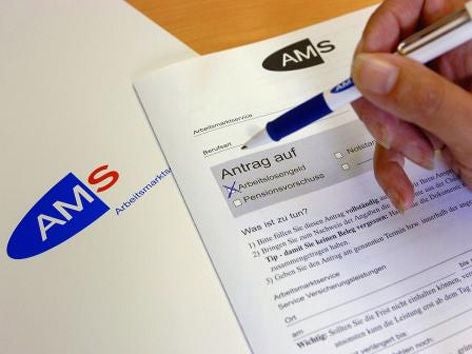 Eine Hand füllt ein Formular vom AMS zum Antrag auf Arbeitslosengeld aus.