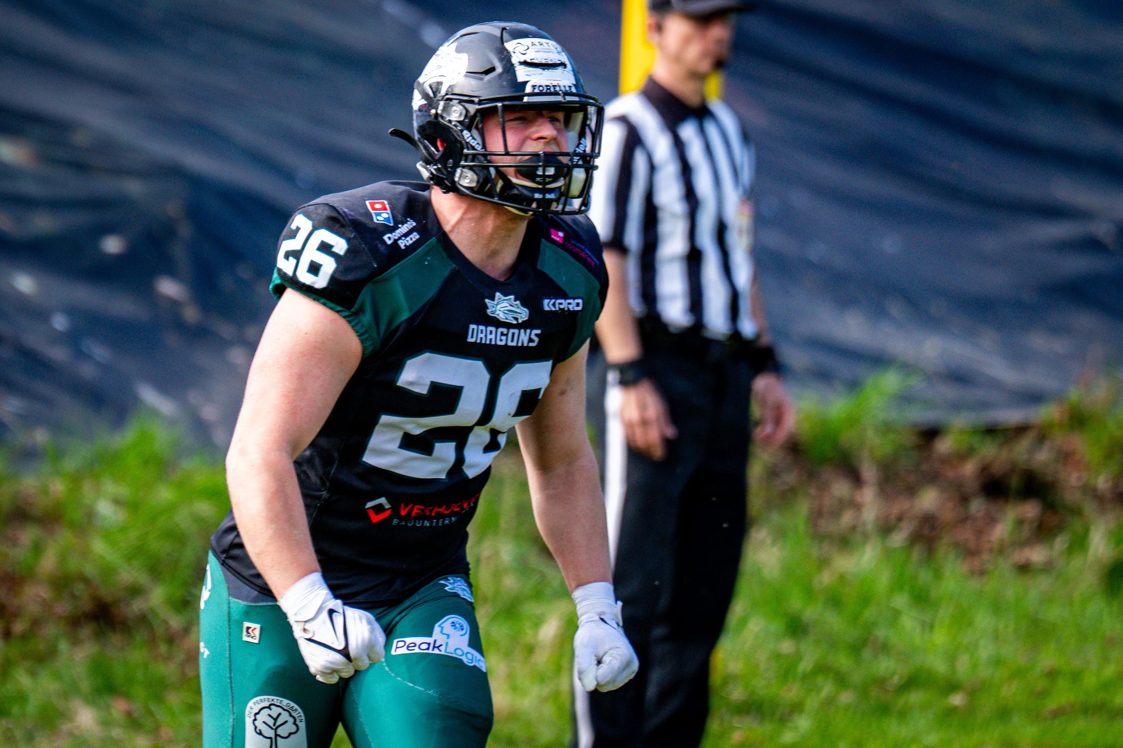 Ein Footballspieler der Danube Dragons jubelt auf dem Spielfeld, im Hintergrund ein Schiedsrichter.