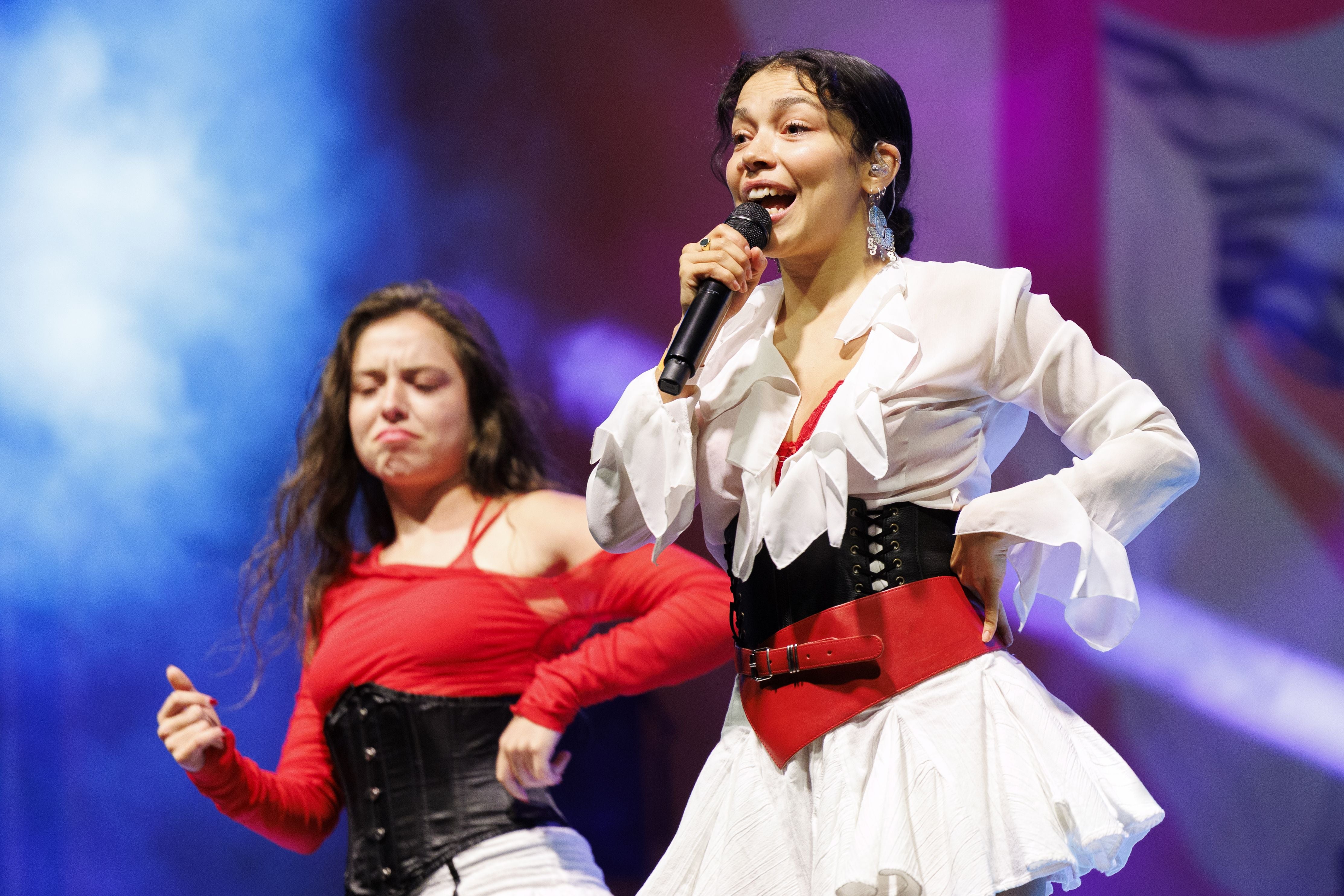 Zwei Künstlerinnen treten mit Mikrofon und Tanzeinlagen auf einer Bühne beim Popfest Wien auf.