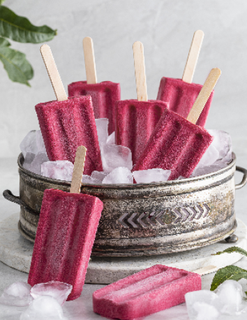 Mehrere rote Eis am Stiel liegen auf Eiswürfeln in einer Metallschale.
