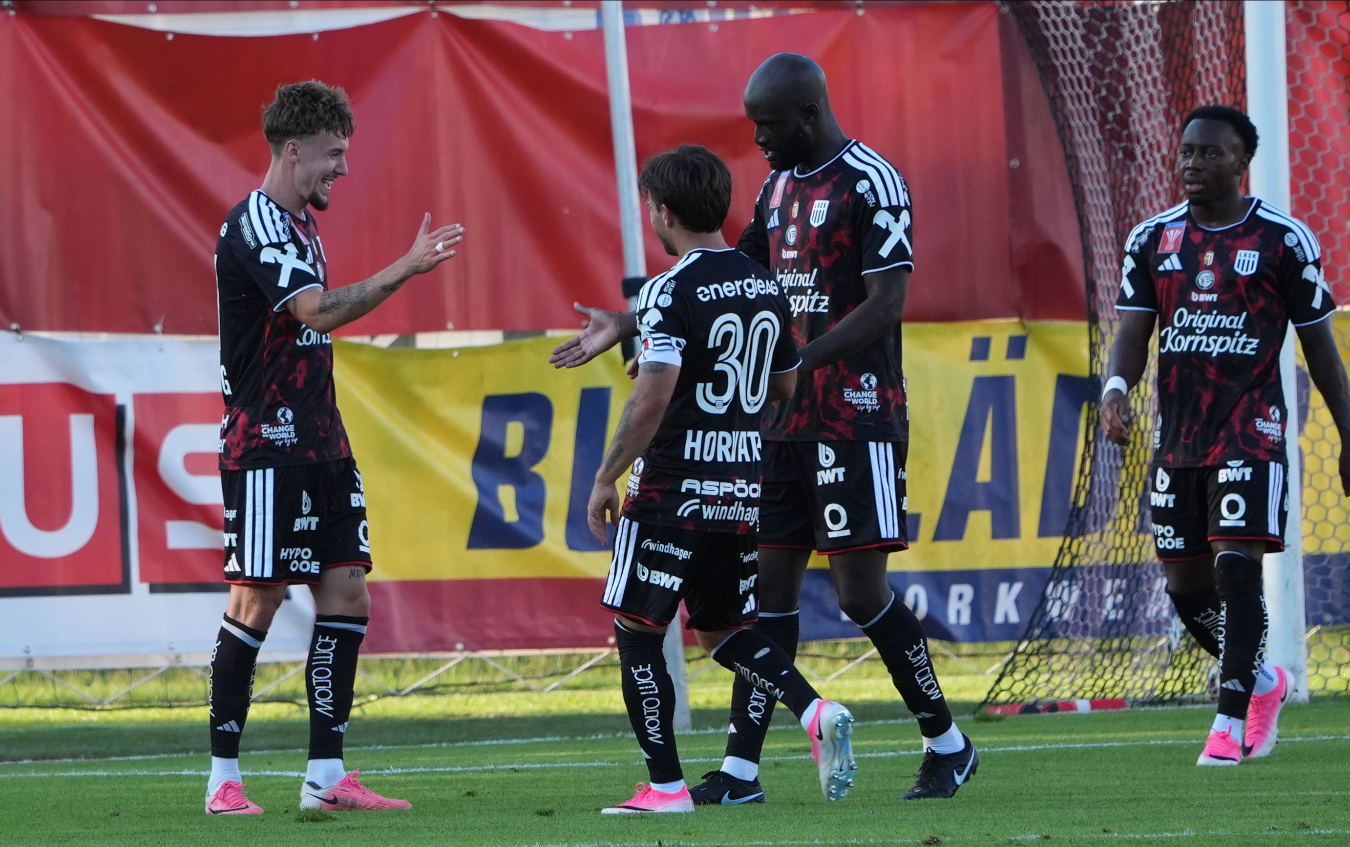 Vier LASK-Spieler jubeln auf dem Spielfeld nach einem Tor beim ÖFB Cup-Spiel in Graz.