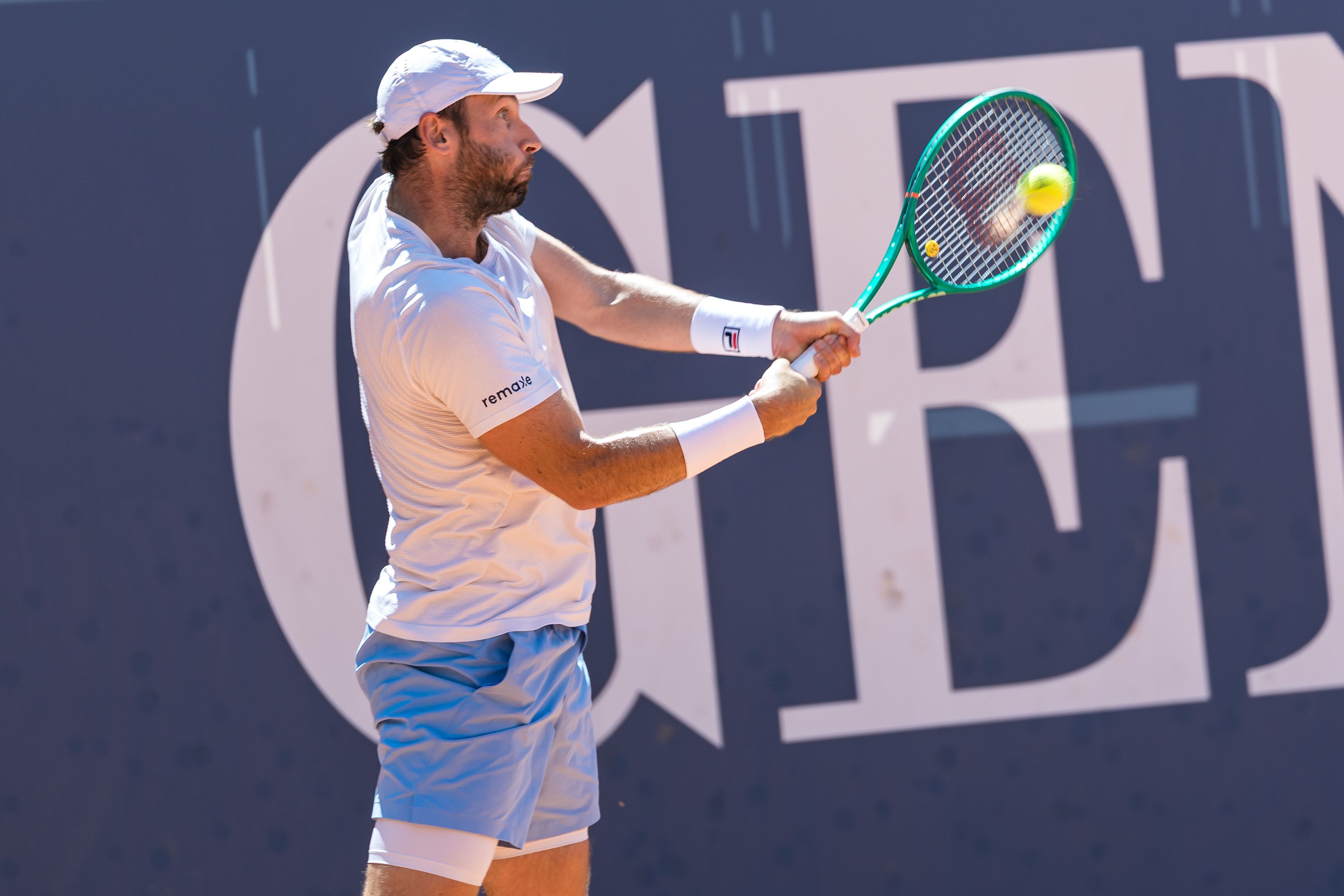 Ein Tennisspieler schlägt während eines Matches mit einer Vorhand den Ball.