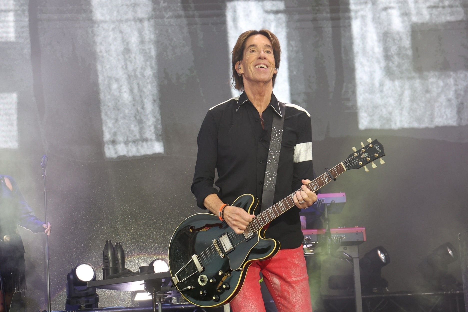 Gitarrist spielt auf der Bühne bei einem Roxette-Konzert in Wien, umgeben von Lichteffekten.