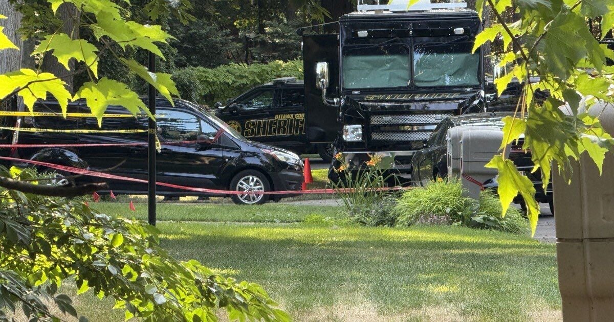 Mehrere Sheriff-Fahrzeuge stehen hinter Absperrband in einem Wohngebiet in Grand Haven Township.