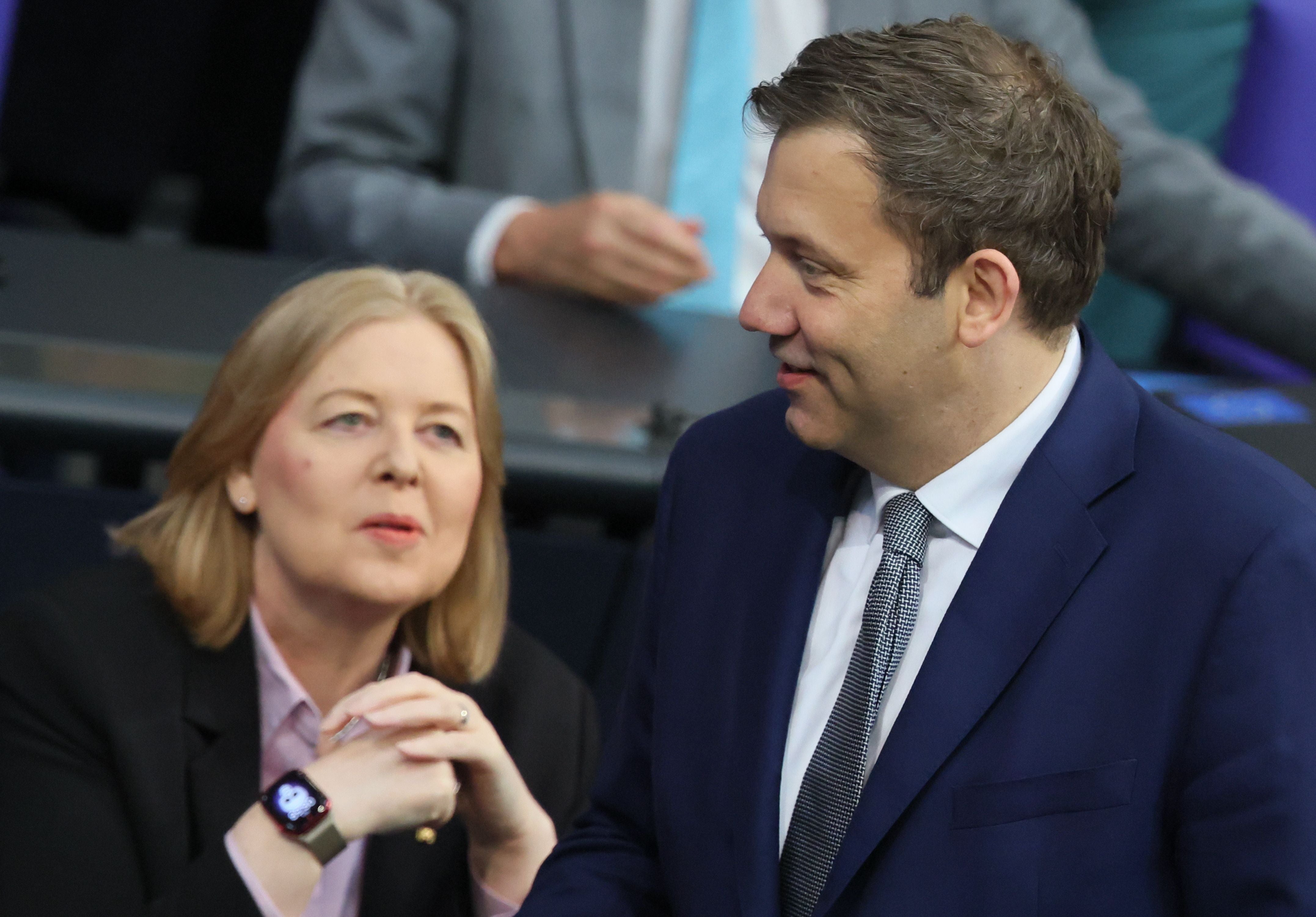 Eine Frau und ein Mann im Anzug unterhalten sich im deutschen Bundestag.