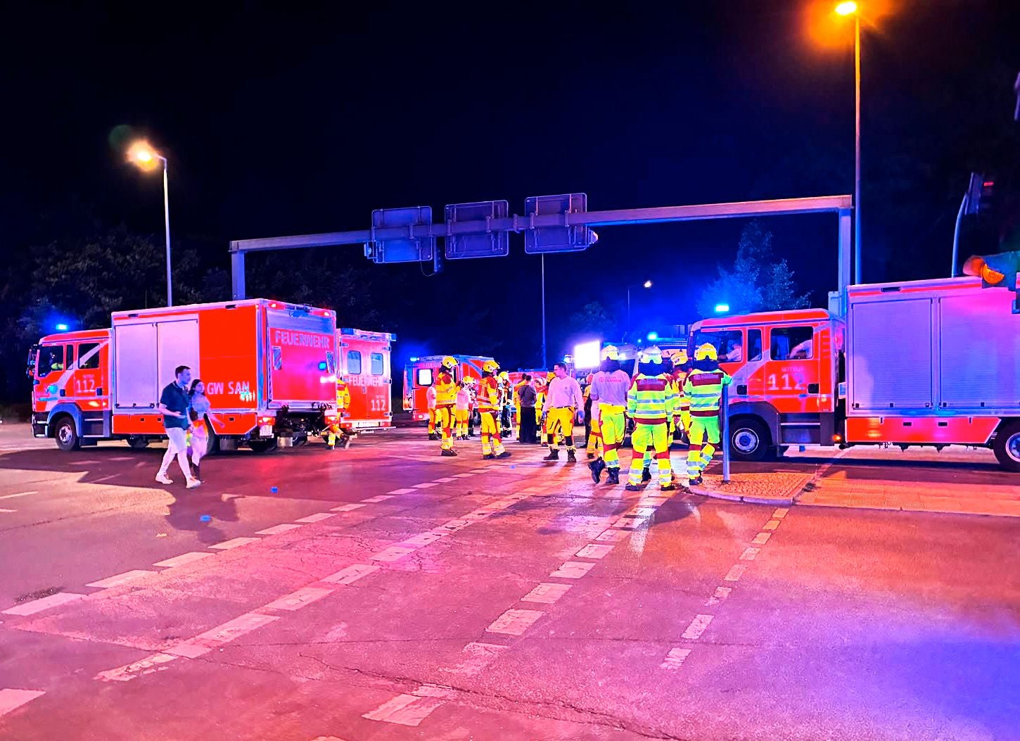 Mehrere Einsatzfahrzeuge und Rettungskräfte nachts an einem Unfallort mit blauem Blinklicht.