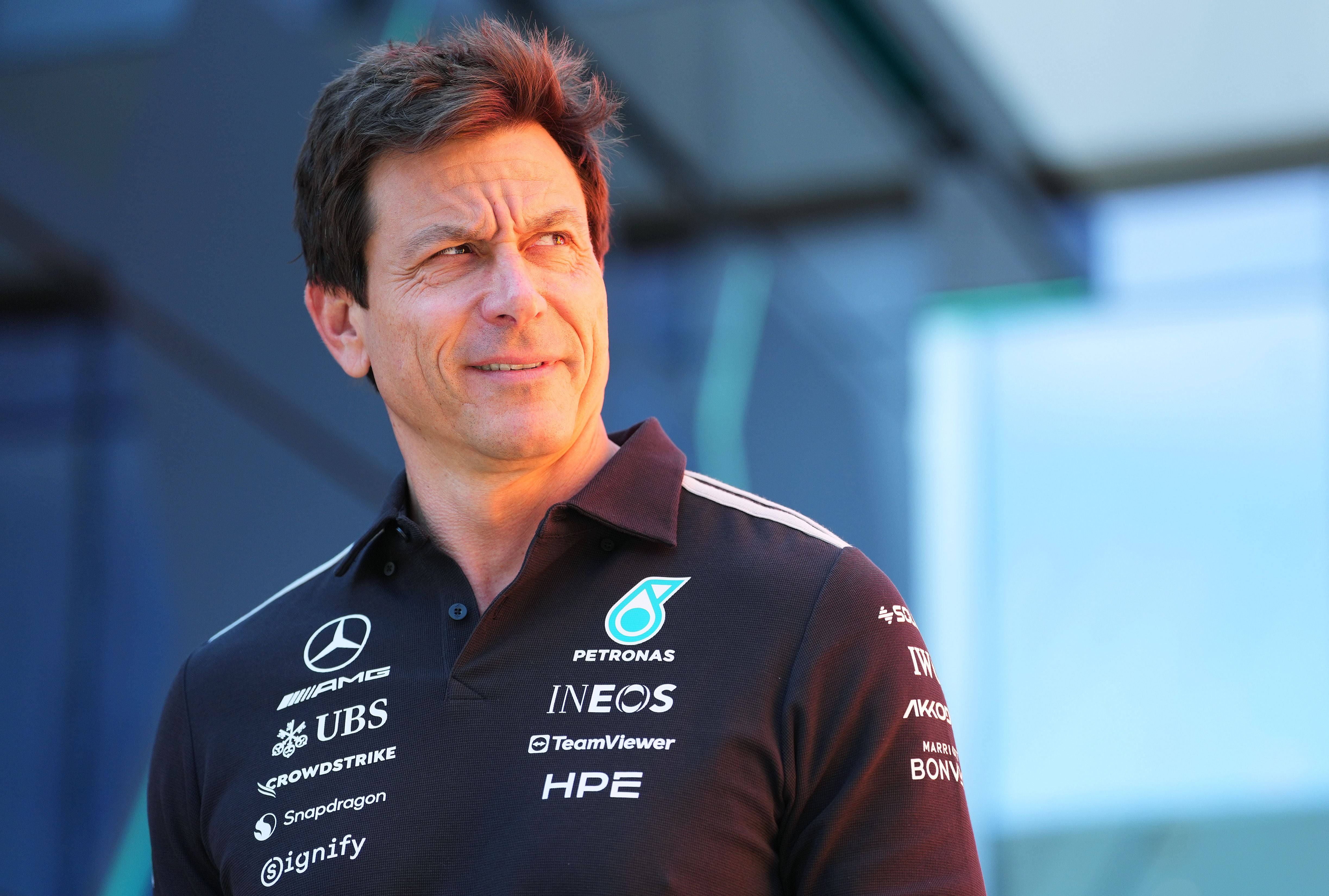 Ein Mann im Mercedes-AMG-Petronas-Poloshirt steht draußen und blickt zur Seite.