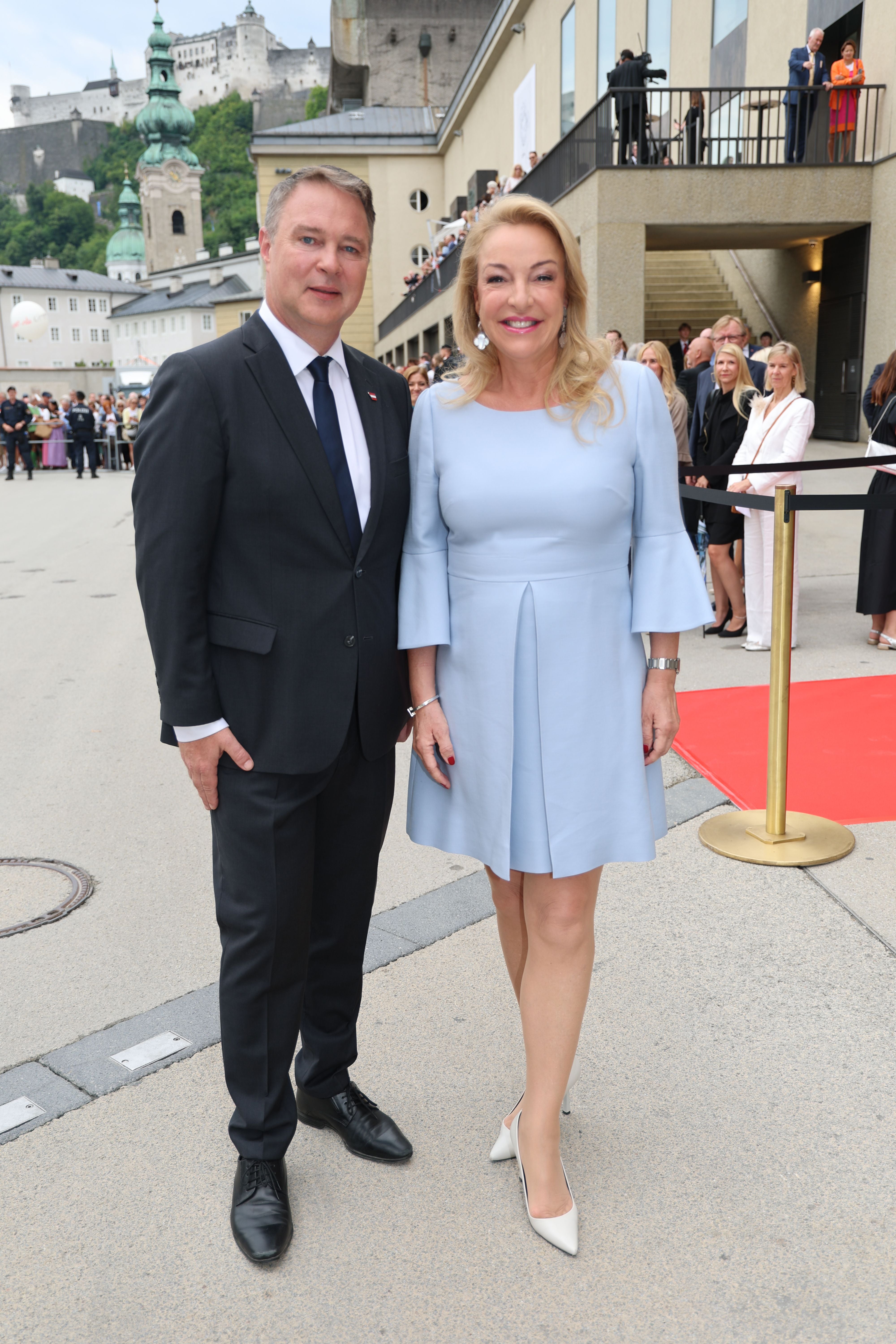 Ein Mann im Anzug und eine Frau im hellblauen Kleid stehen bei der Eröffnung der Salzburger Festspiele.