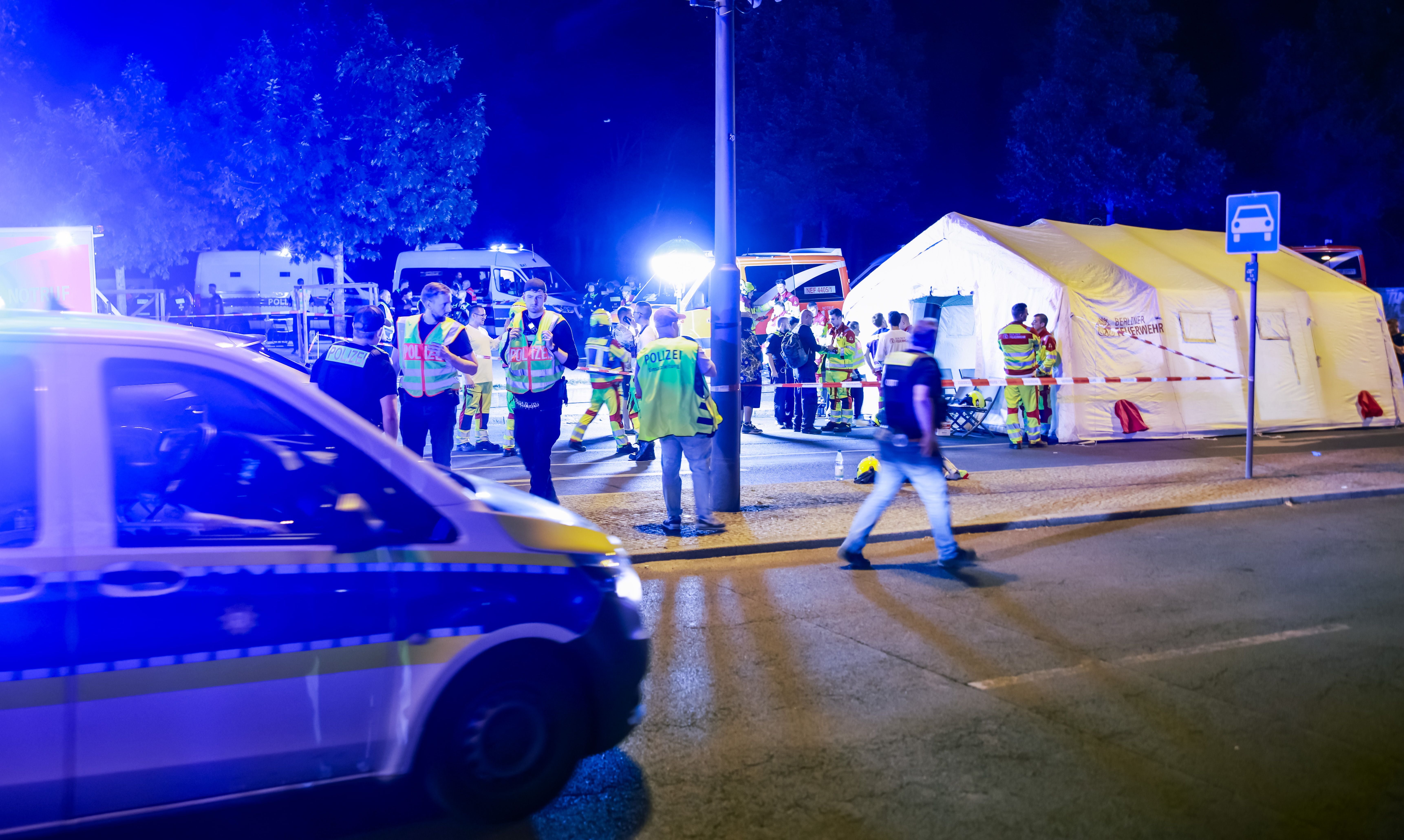 Polizei und Einsatzkräfte sichern nachts ein Unfallgebiet mit großem Zelt und mehreren Einsatzfahrzeugen.
