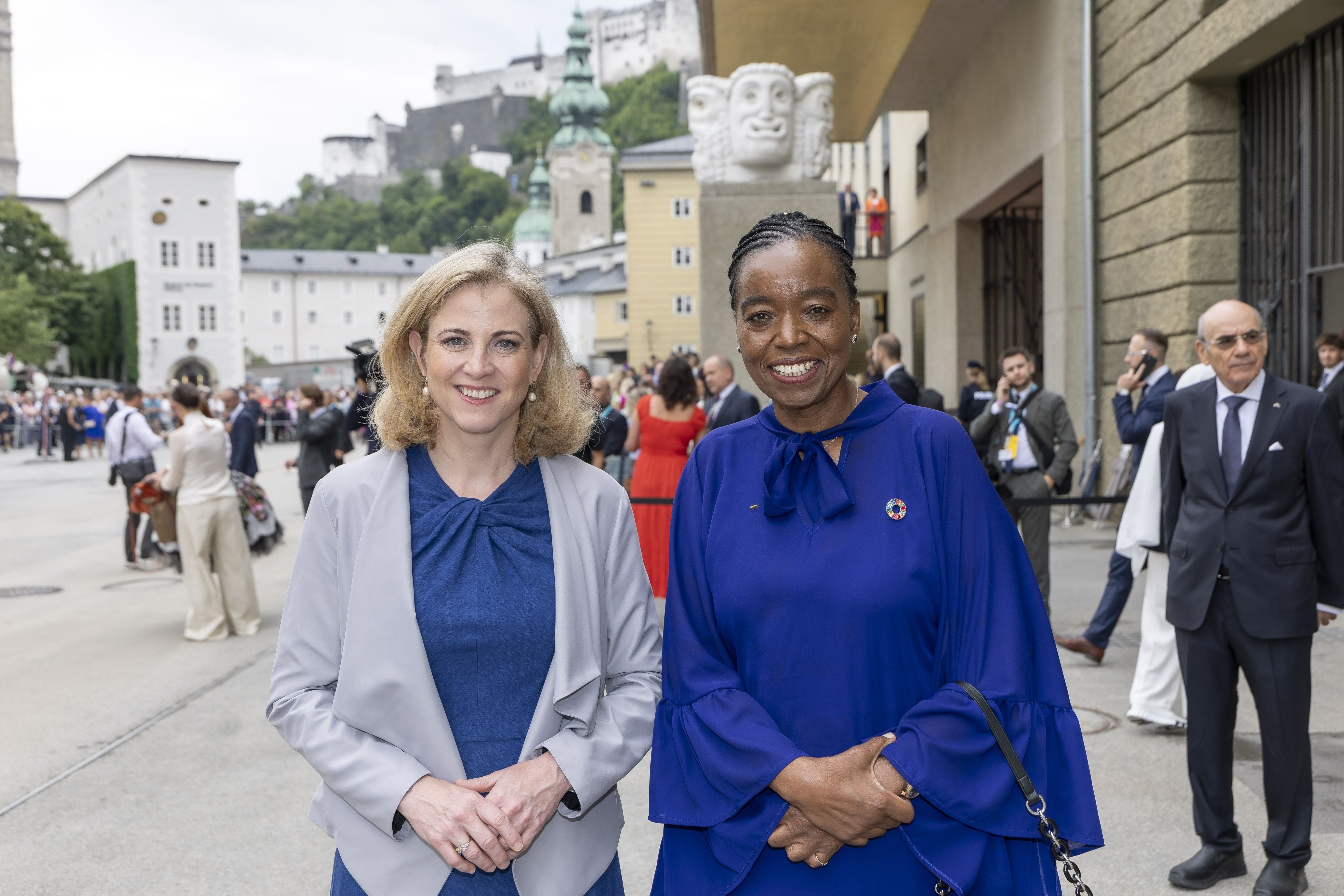 Zwei Frauen stehen nebeneinander bei einer Veranstaltung im Freien in Salzburg.