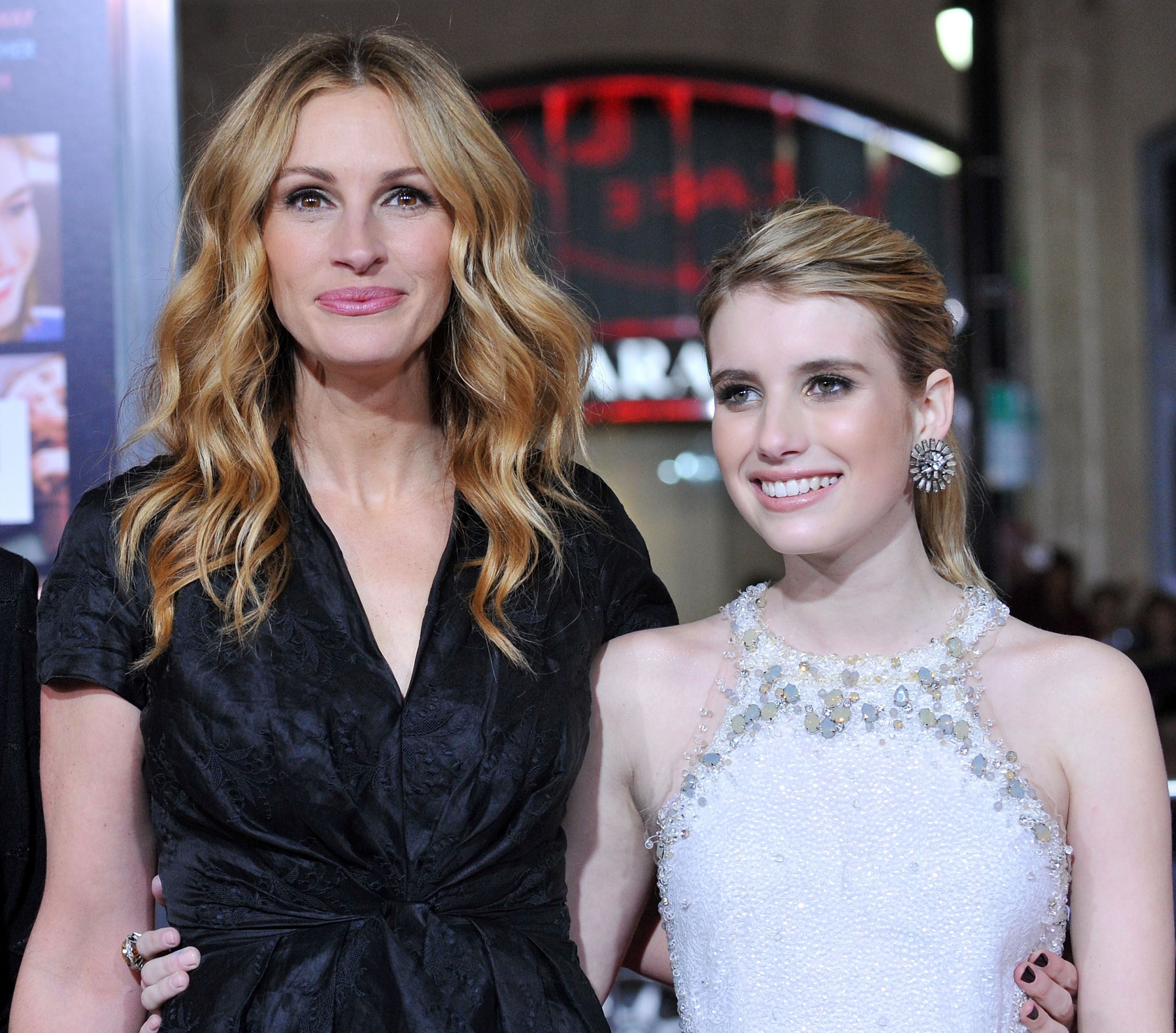 Zwei Frauen posieren lächelnd zusammen auf einem roten Teppich bei einer Filmpremiere.