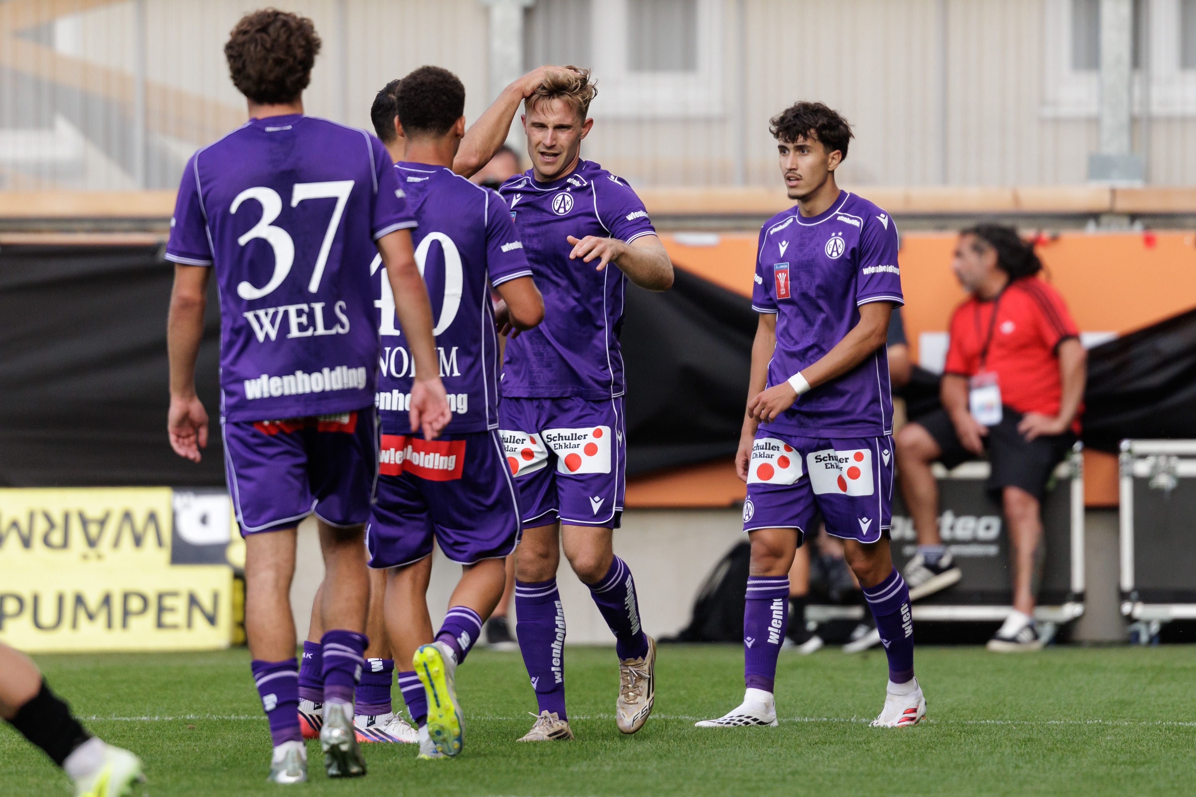 Mehrere Fußballspieler von Austria Wien jubeln gemeinsam auf dem Spielfeld.