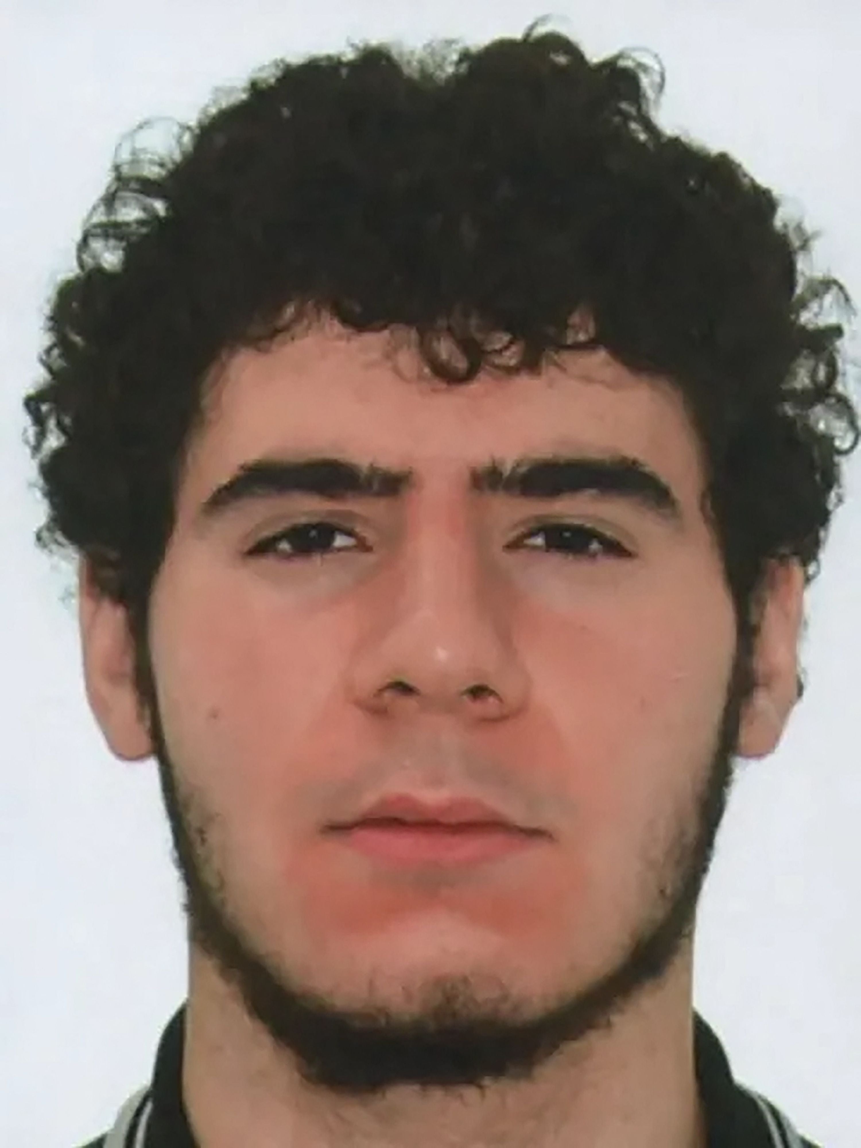 Porträtfoto eines jungen Mannes mit dunklen Lockenbart und neutralem Gesichtsausdruck.