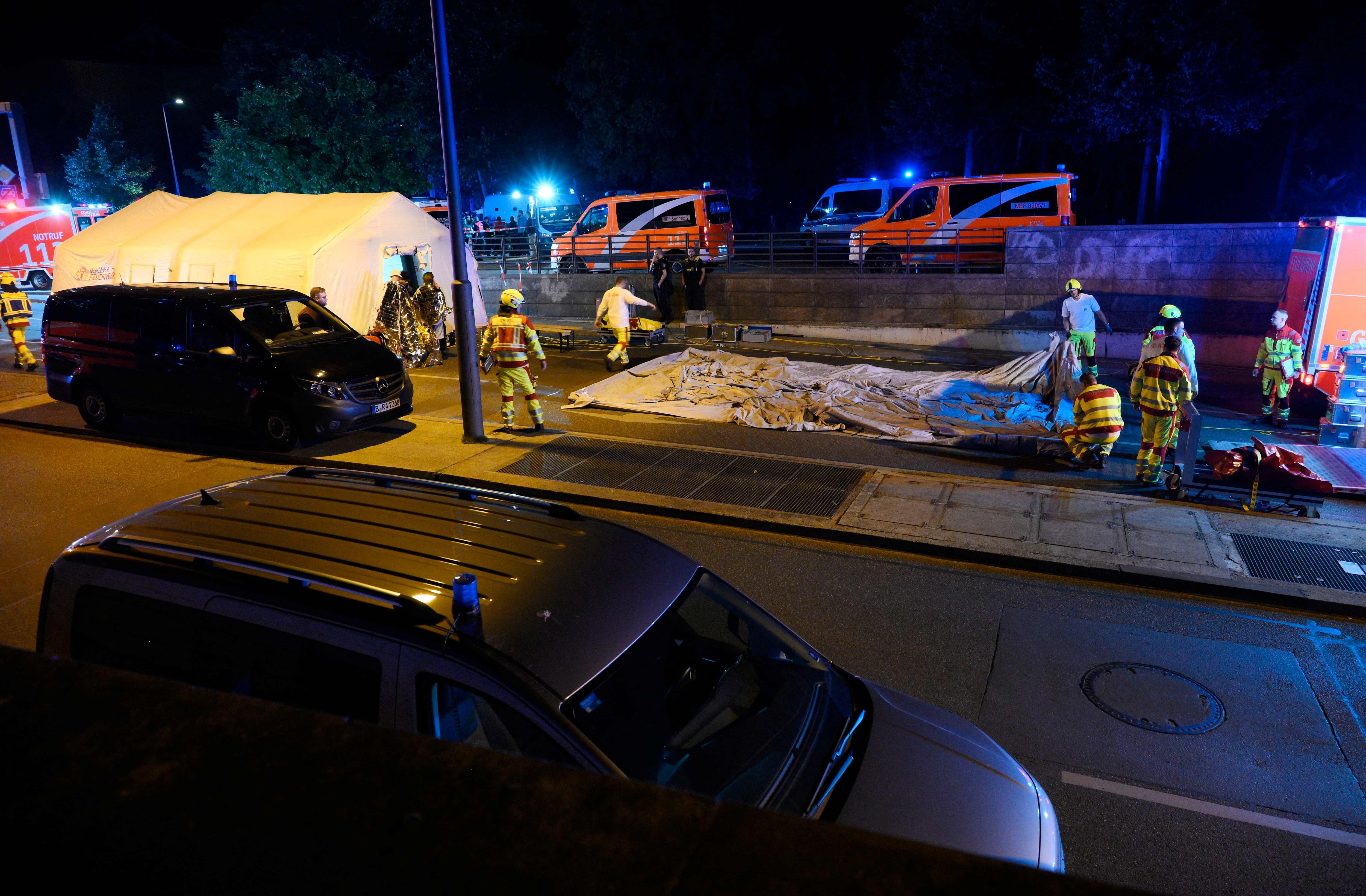 Rettungskräfte und Polizei arbeiten nachts an einem Unfallort mit mehreren Krankenwagen in Berlin.