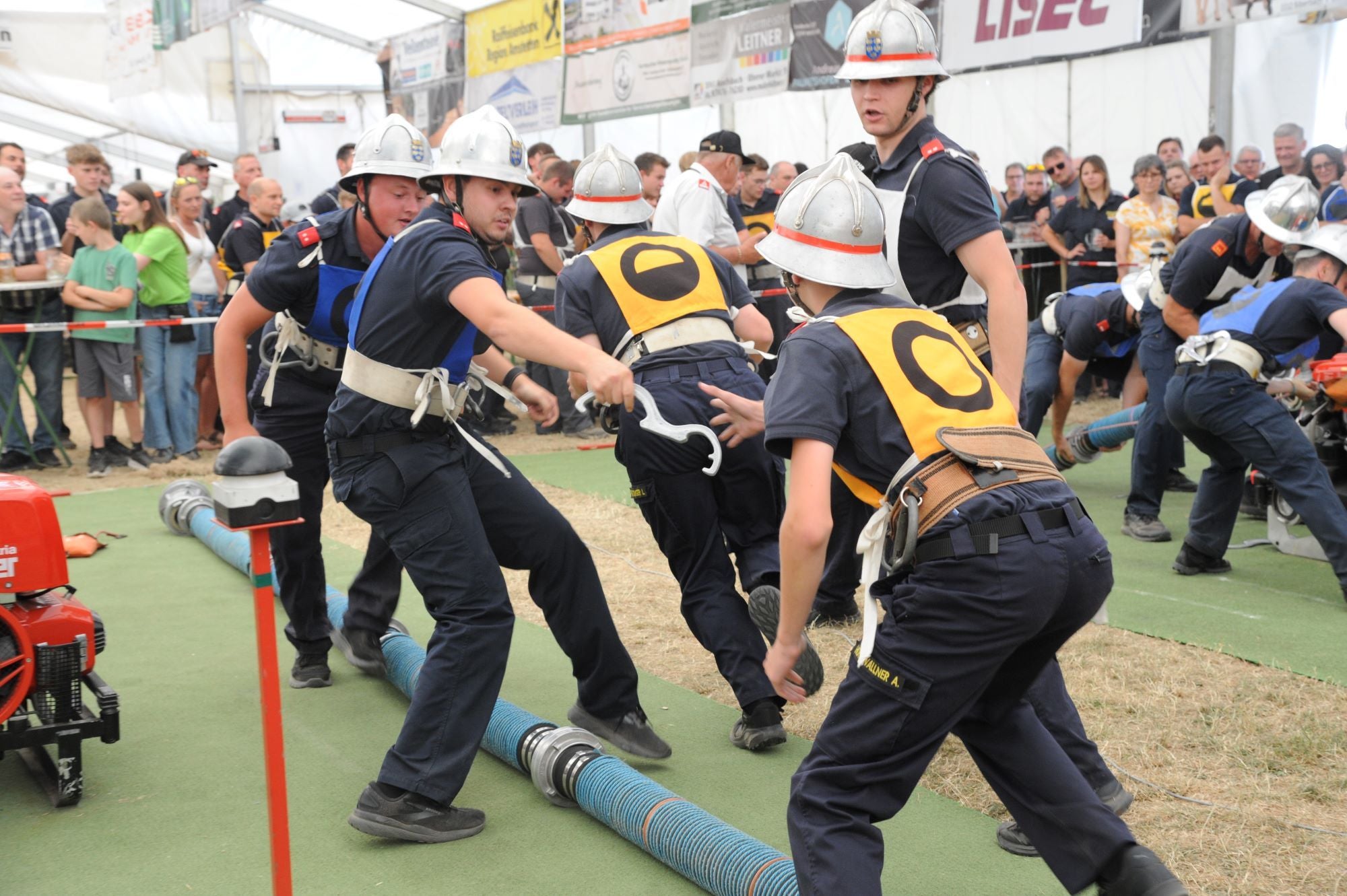 Jugendliche in Feuerwehruniformen nehmen an einem Feuerwehrwettbewerb teil.