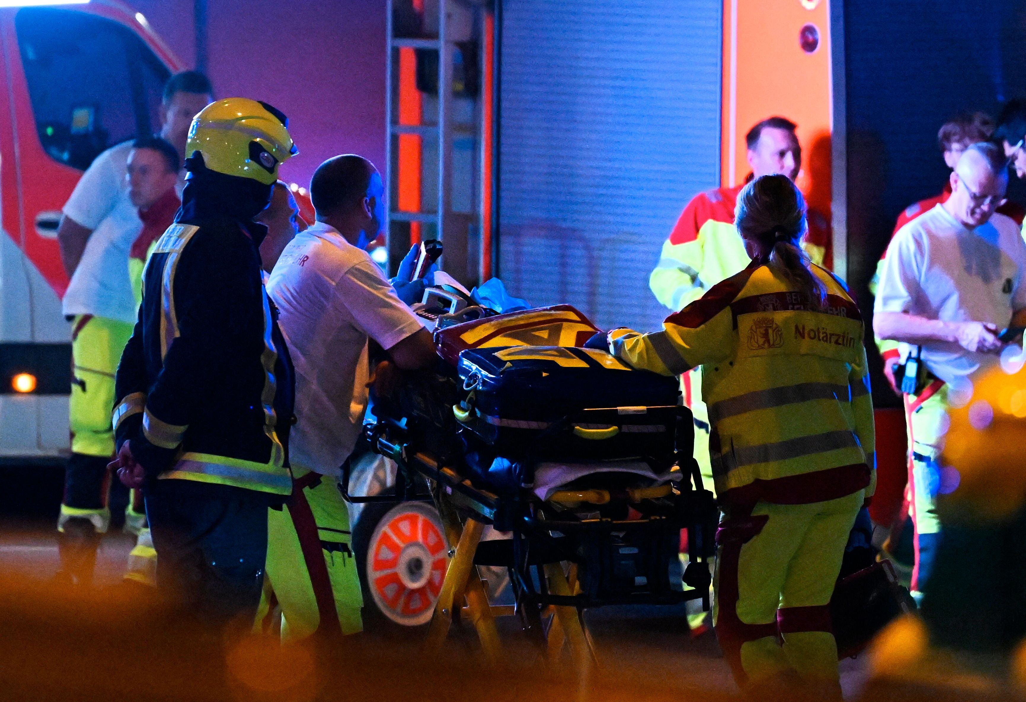 Rettungskräfte versorgen bei Nacht Verletzte auf einer Trage nach einem Unfall mit mehreren Opfern.