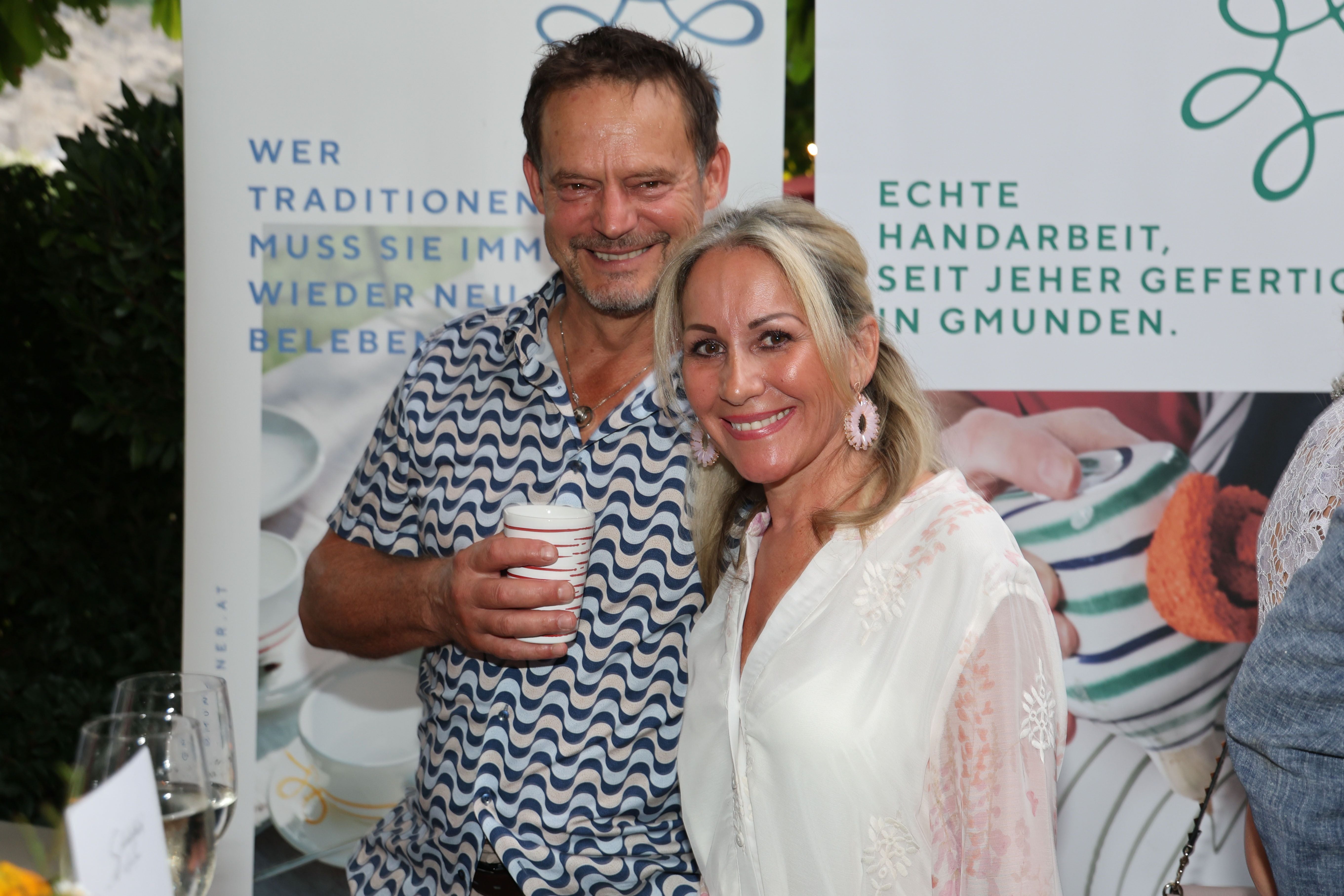 Ein Mann und eine Frau lächeln bei einer Veranstaltung in Salzburg in die Kamera.