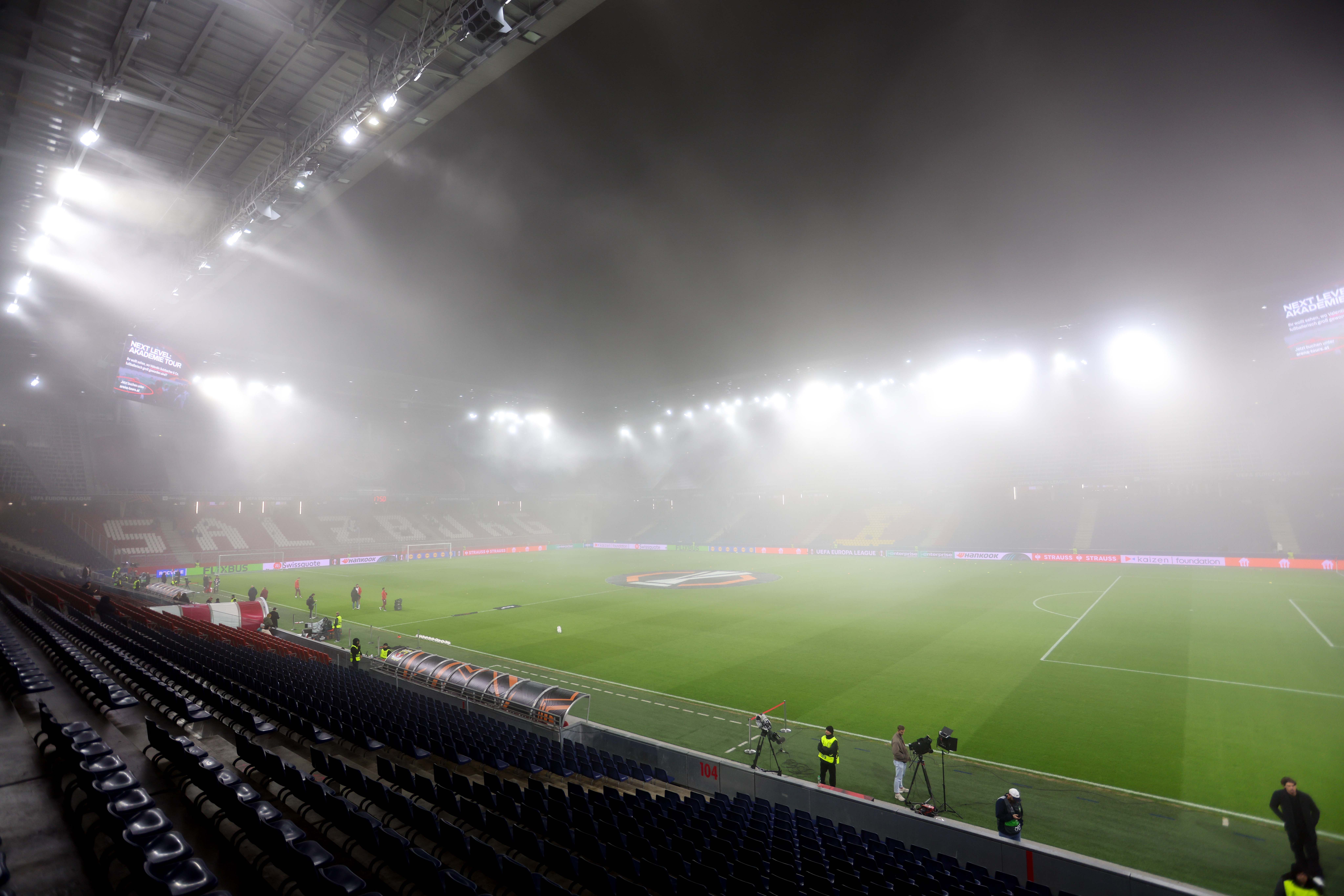 Das Red Bull Arena in Salzburg ist im dichten Nebel und mit Flutlicht beleuchtet.