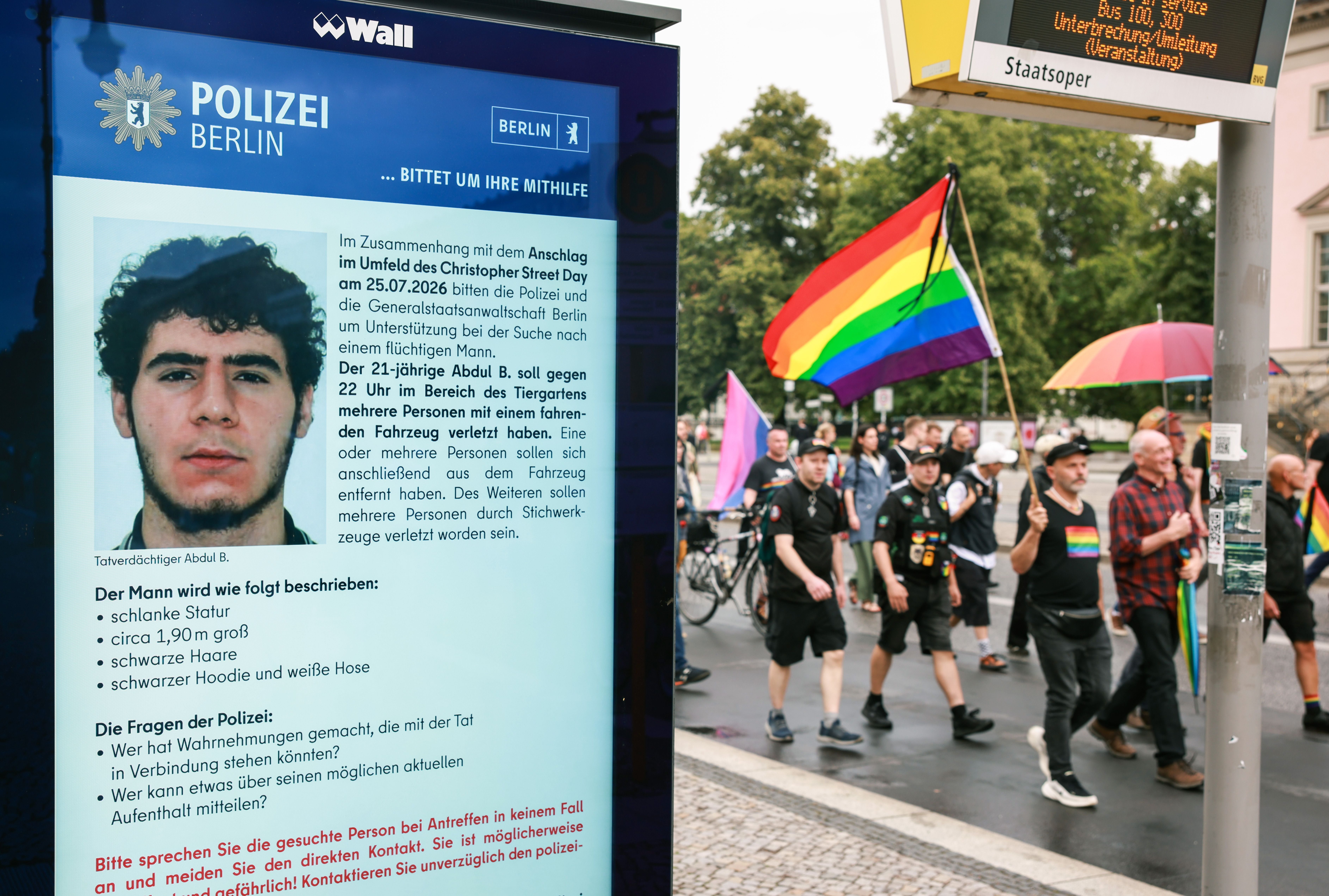 Trauermarsch mit Regenbogenfahnen passiert Polizeifahndung nach Tatverdächtigem in Berlin.