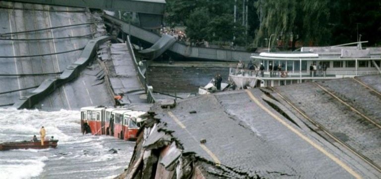 Die eingestürzte Wiener Reichsbrücke liegt zerstört in der Donau, Fahrzeuge sind im Wasser.