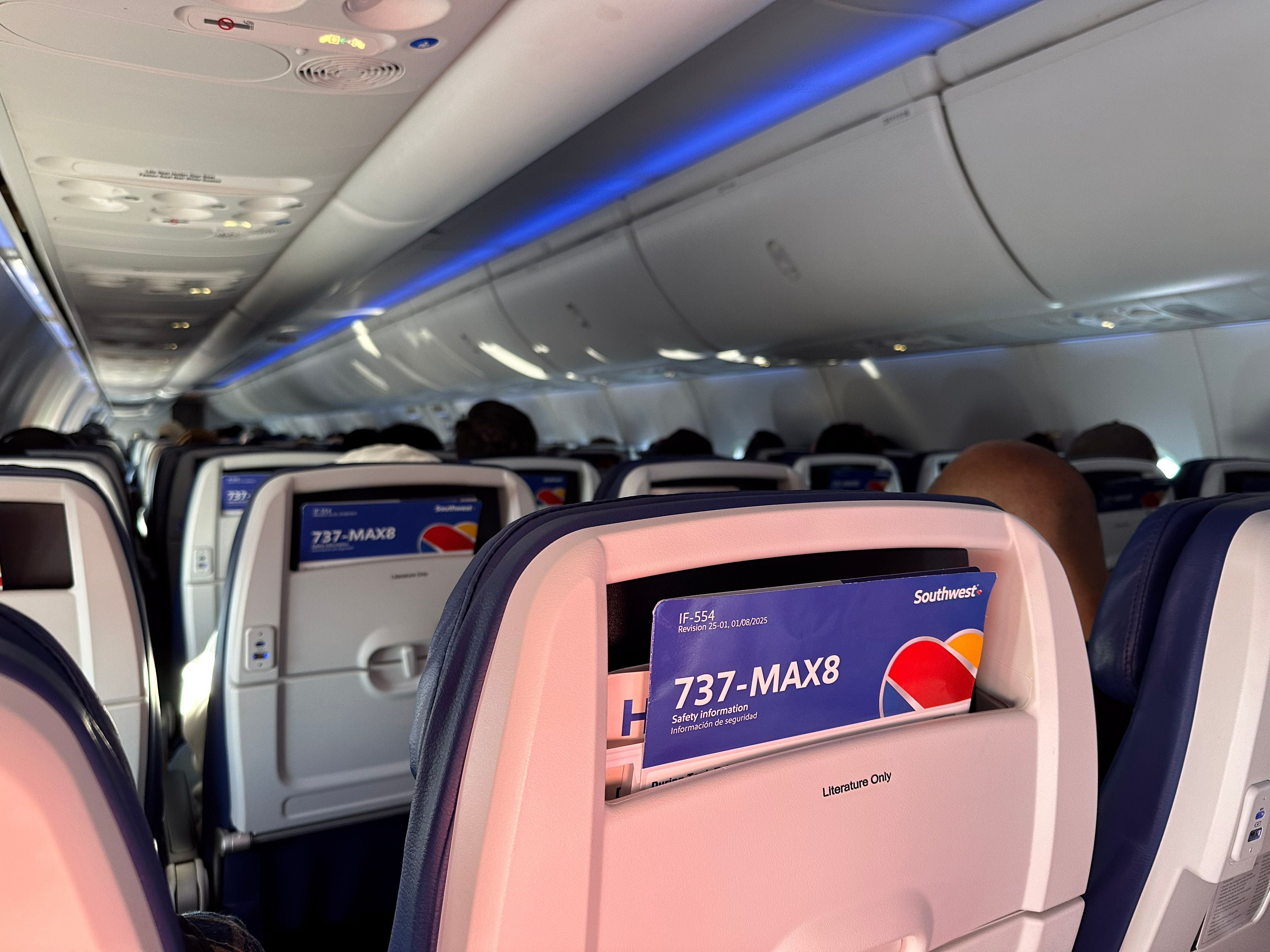 Kabine eines Passagierflugzeugs mit Sitzlehnen und Sicherheitsanweisungen für Boeing 737-MAX 8.