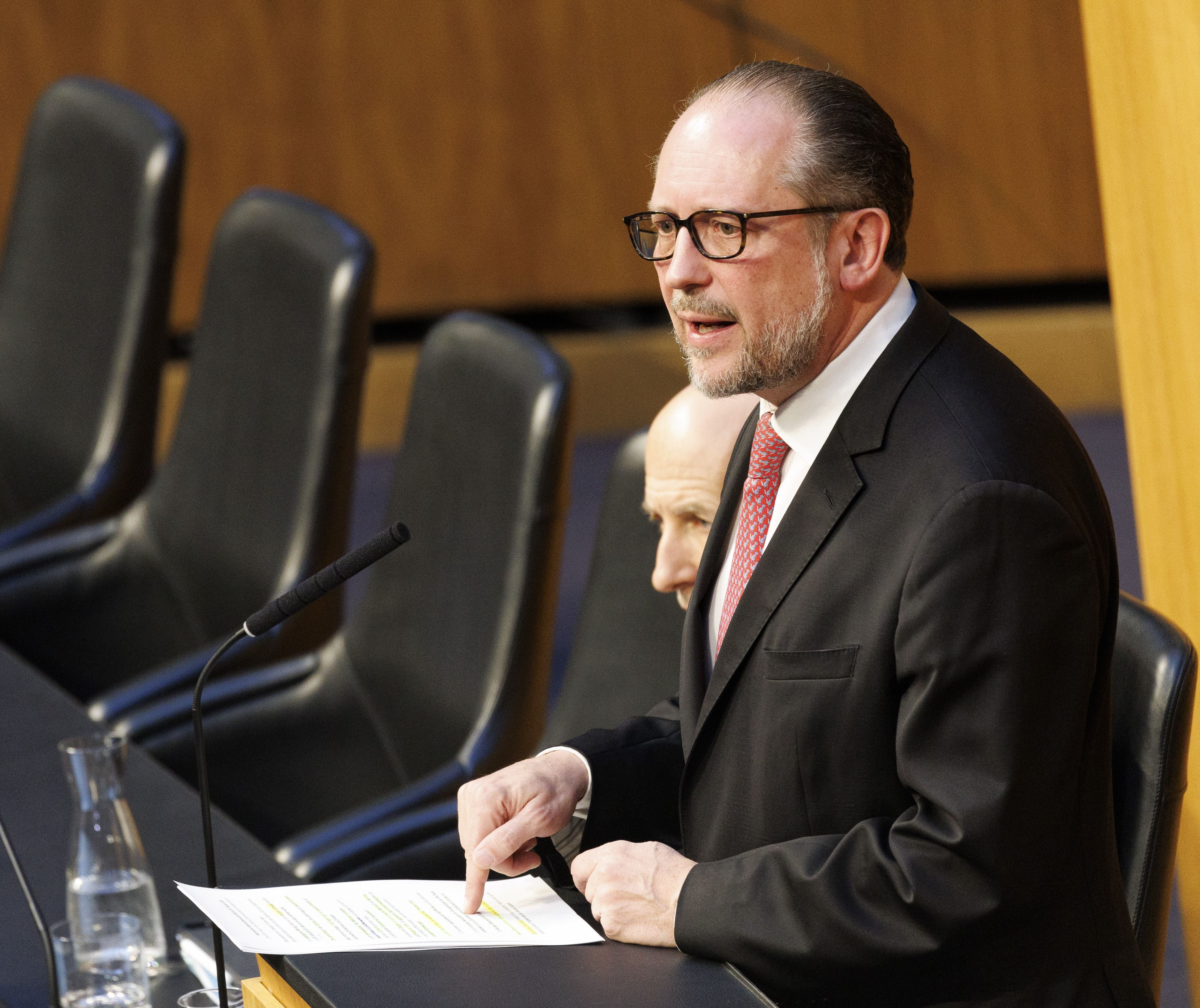 Mann im Anzug spricht bei einer Nationalratssitzung am Rednerpult im Parlament.