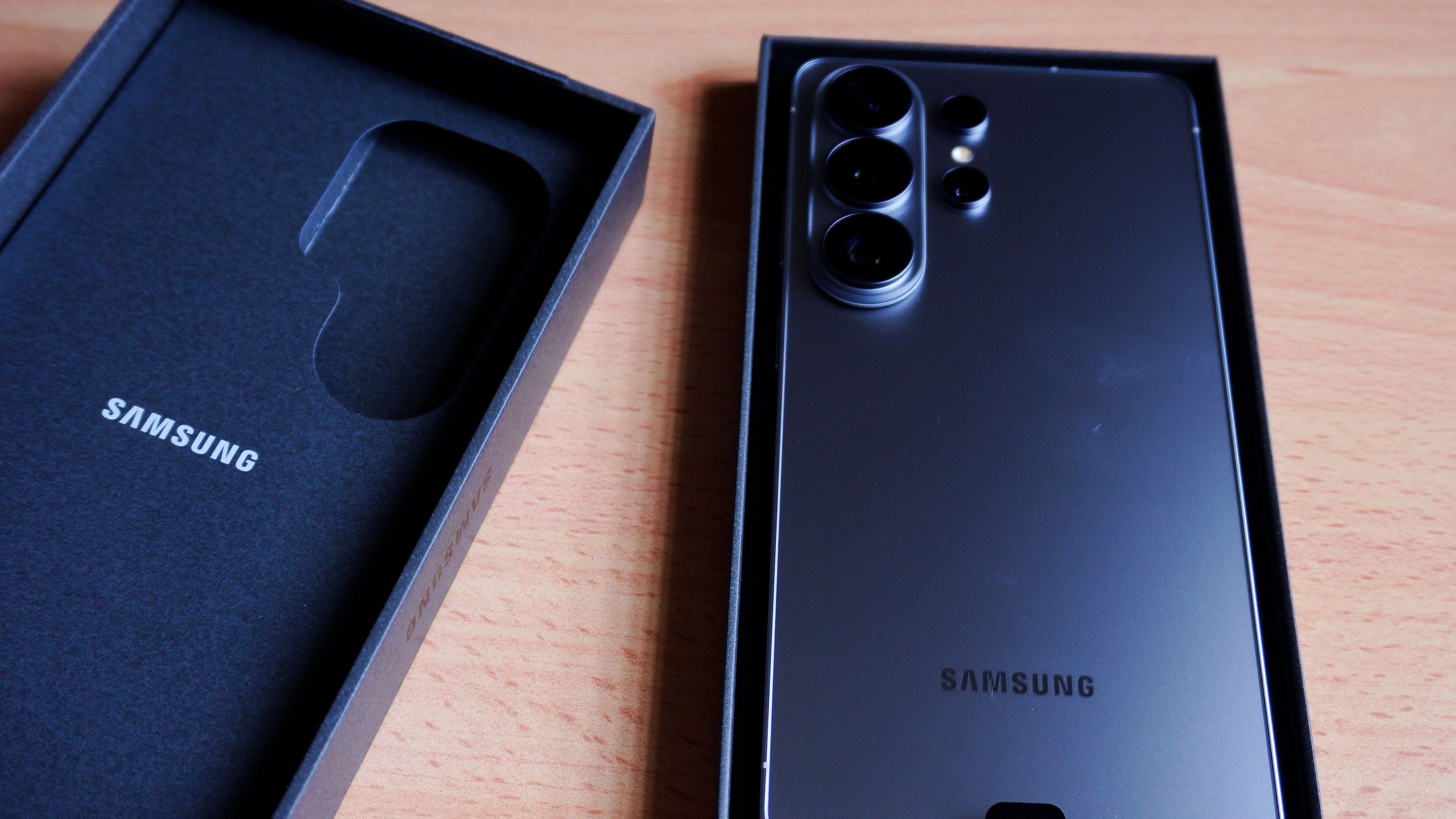 Schwarzes Samsung Galaxy S26 Ultra in eleganter Verpackung beim Auspacken auf Holztisch.