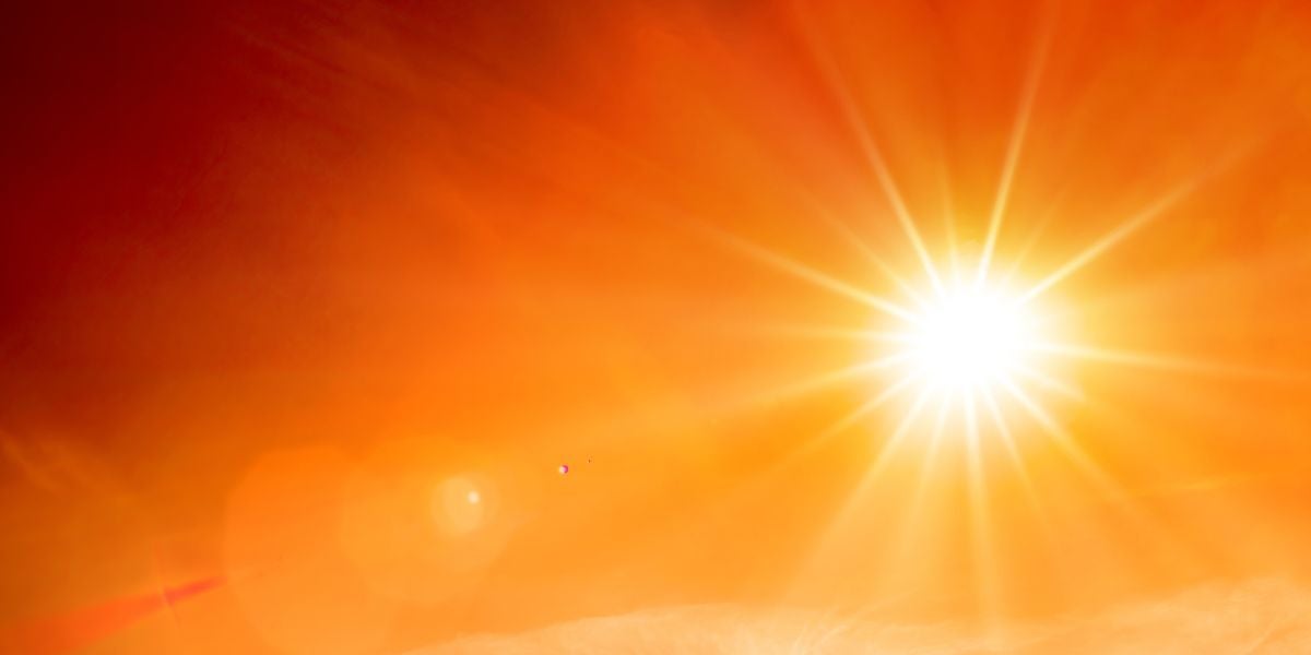 Strahlende Sonne am orangefarbenen Himmel, Hitze ist deutlich spürbar.
