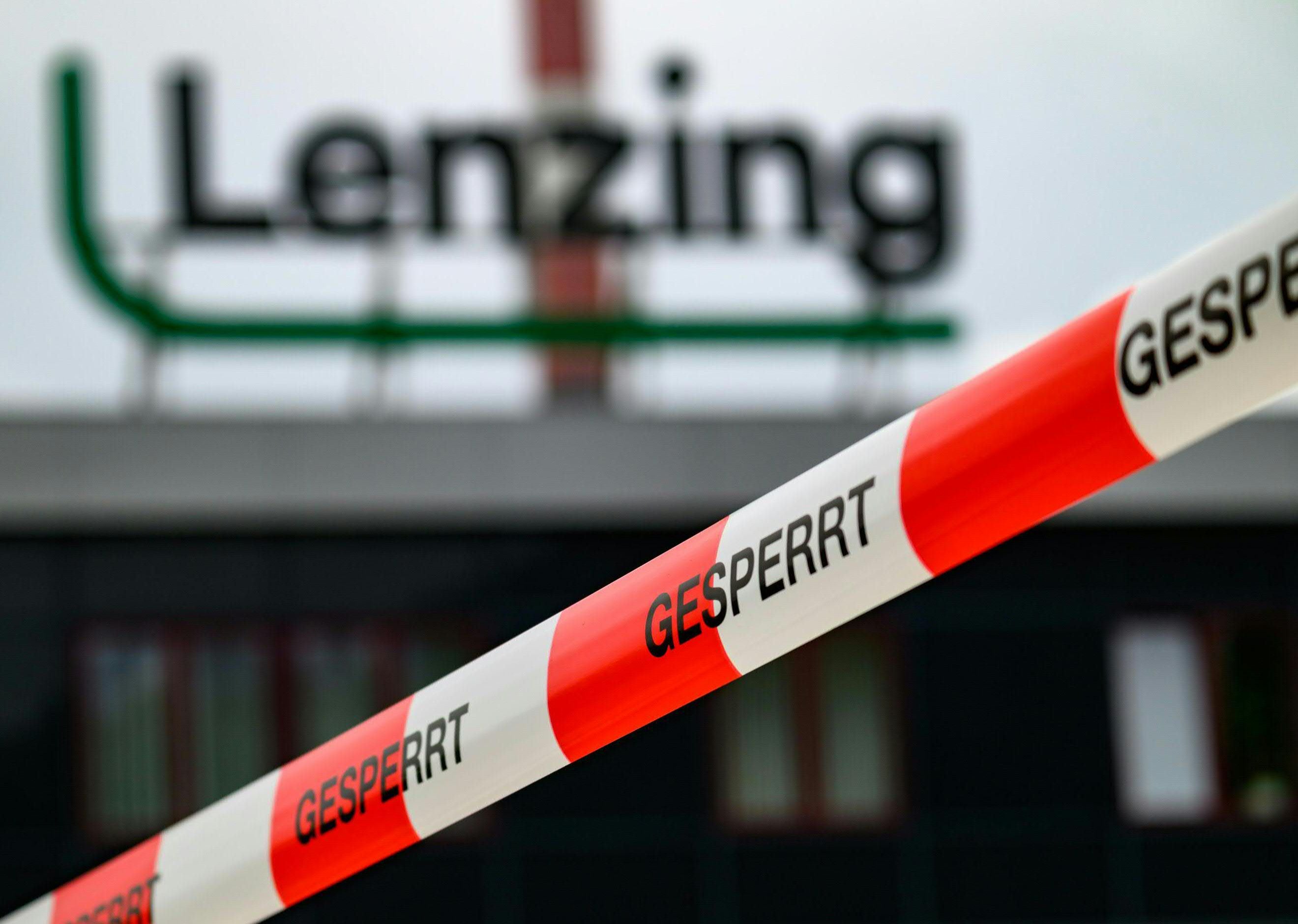 Absperrband mit der Aufschrift „GESPERRT“ vor dem unscharfen Lenzing-Logo im Hintergrund.