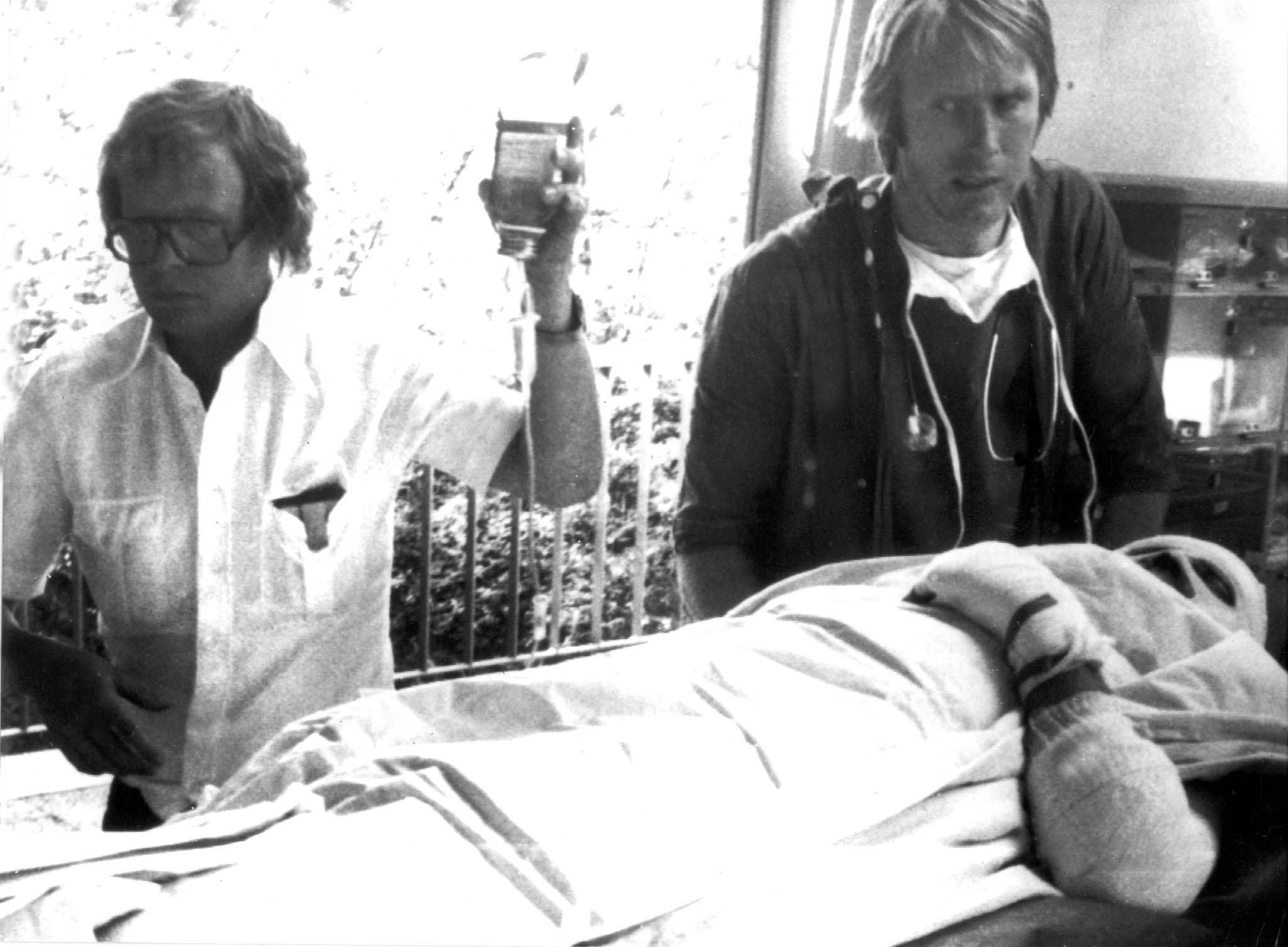 Zwei Ärzte behandeln einen schwer verletzten Patienten auf einer Trage in einer Klinik.