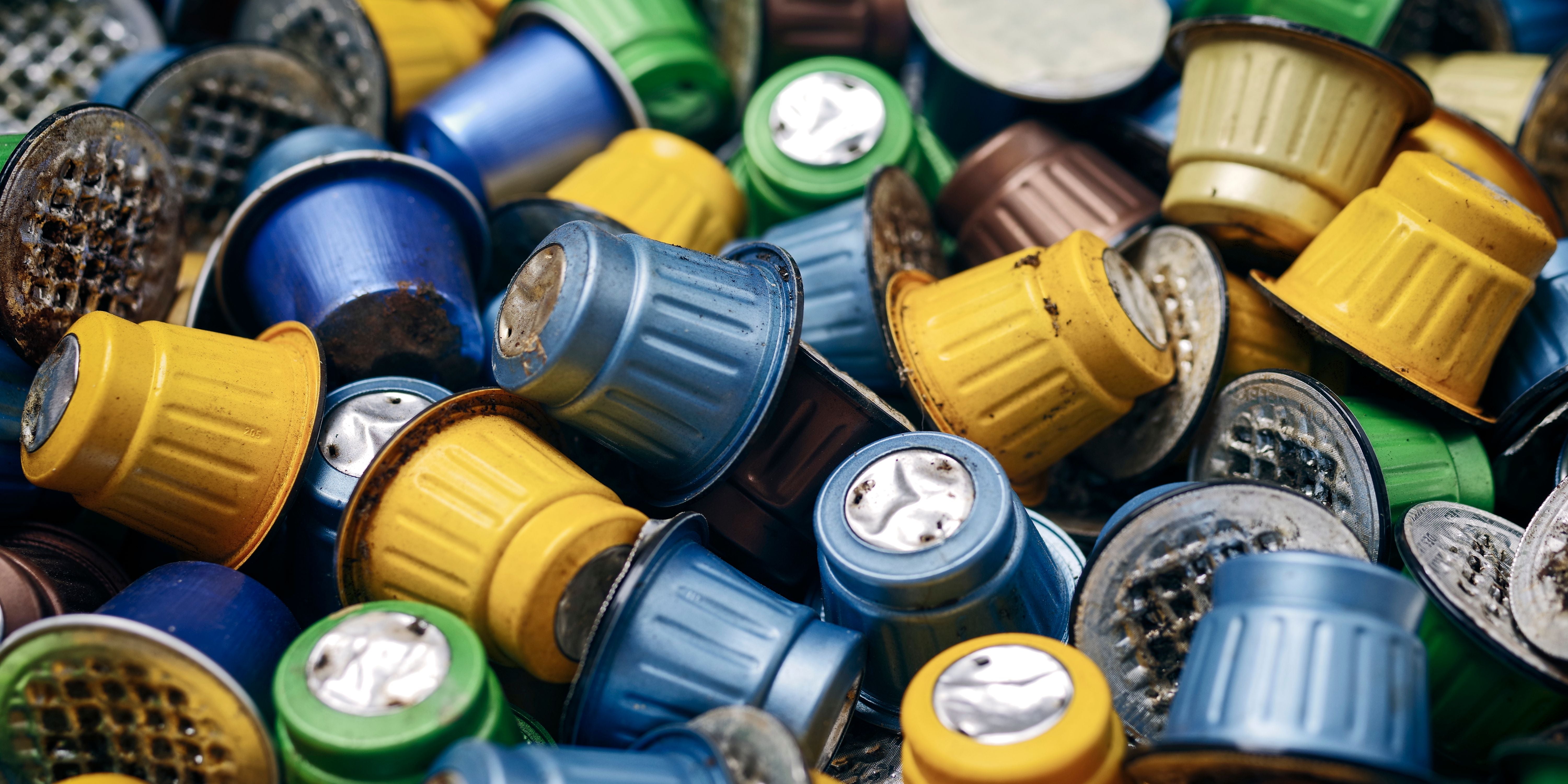 Viele bunte, gebrauchte Kaffeekapseln liegen unsortiert nebeneinander.