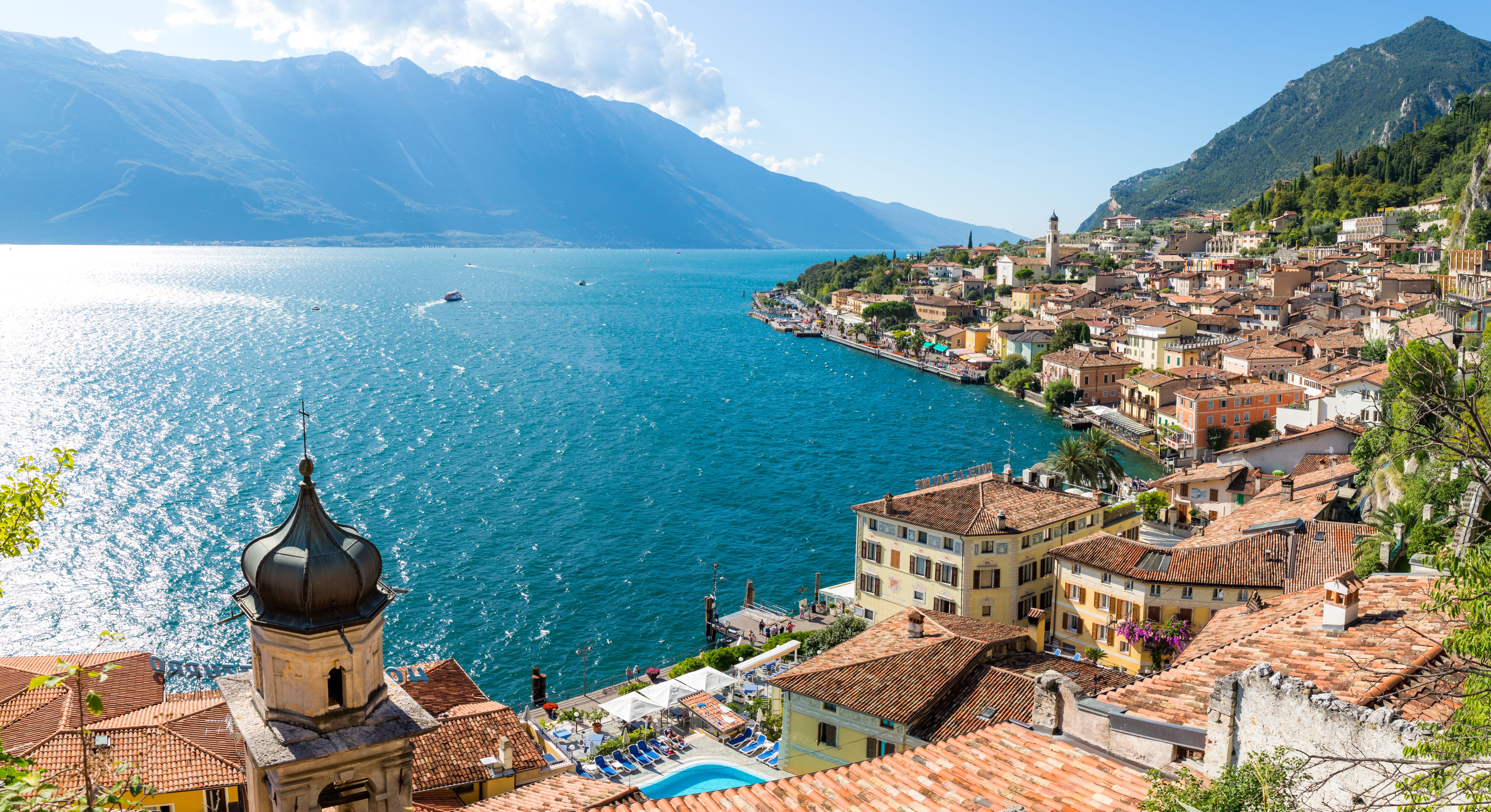 Blick auf Limone sul Garda mit Altstadt und türkisblauem Gardasee vor Bergkulisse.