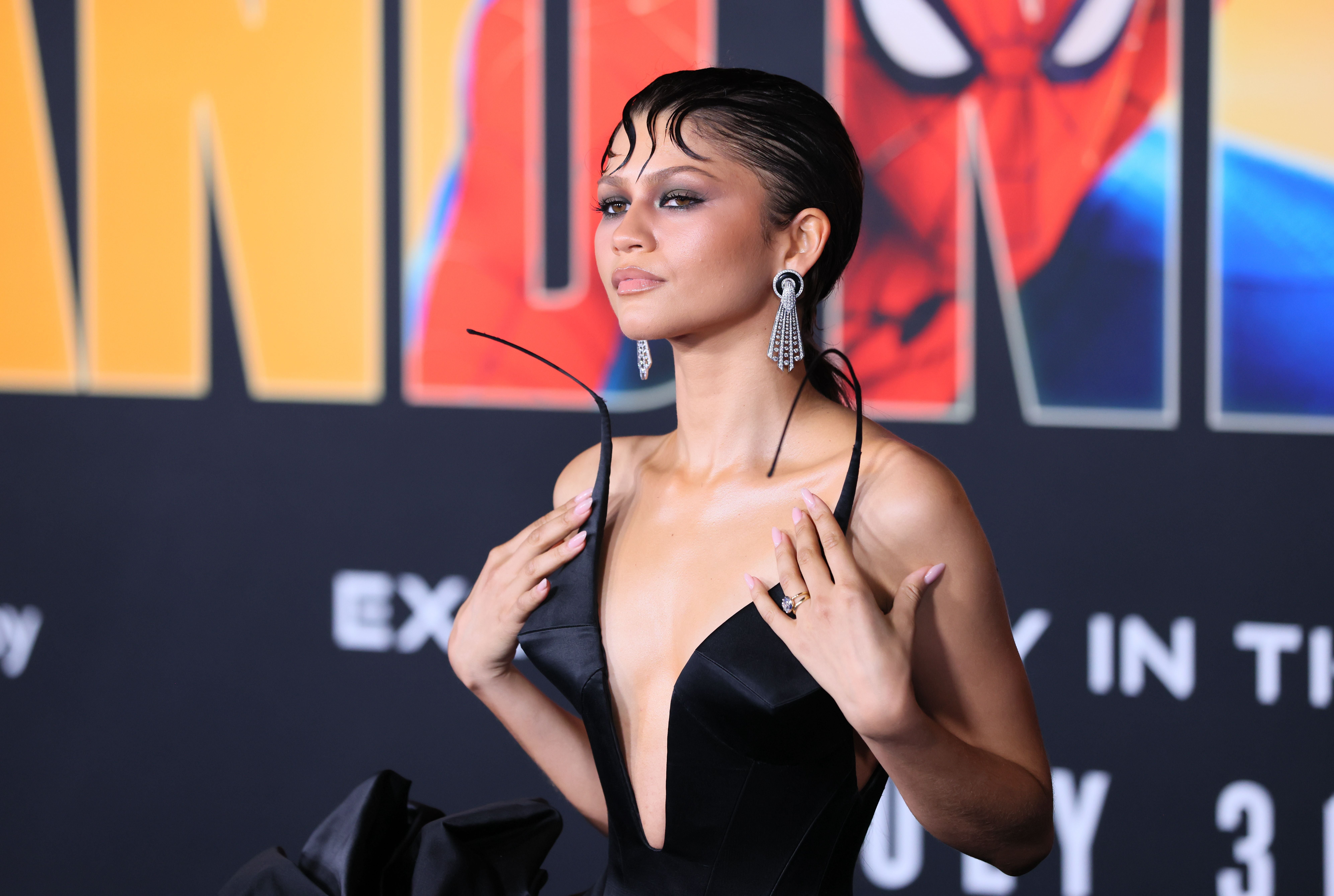 Zendaya in elegant schwarzer Robe auf dem roten Teppich bei einer Spider-Man-Premiere.