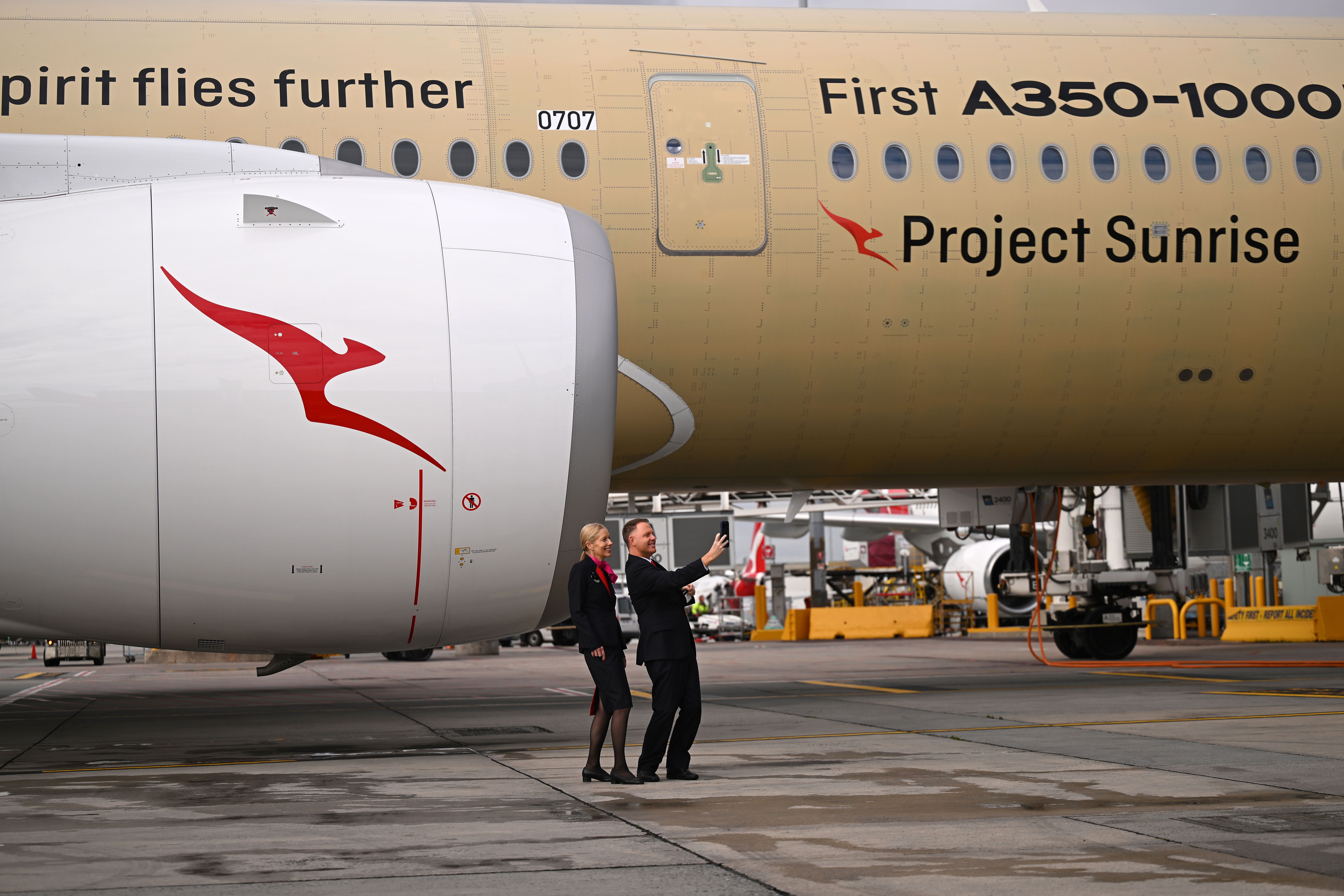 Zwei Qantas-Mitarbeiter machen ein Selfie vor einem Airbus A350-1000ULR mit Project-Sunrise-Logo.