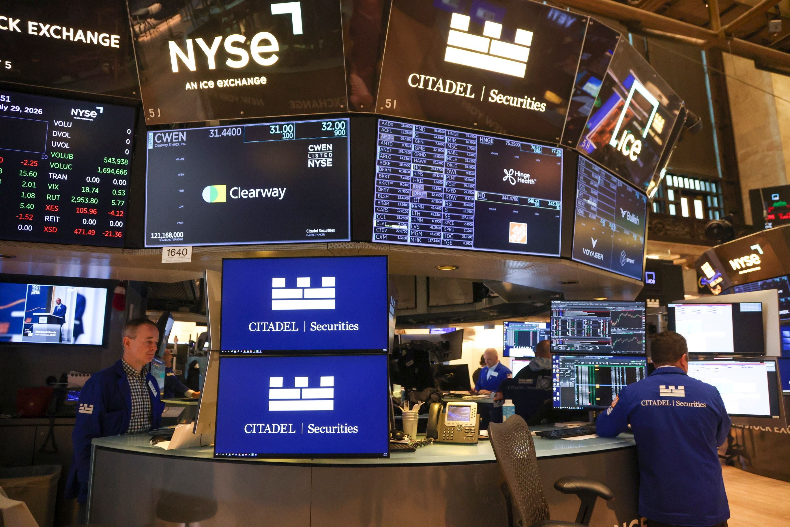Händler arbeiten auf dem Parkett der New Yorker Börse mit vielen Bildschirmen und Finanzdaten.