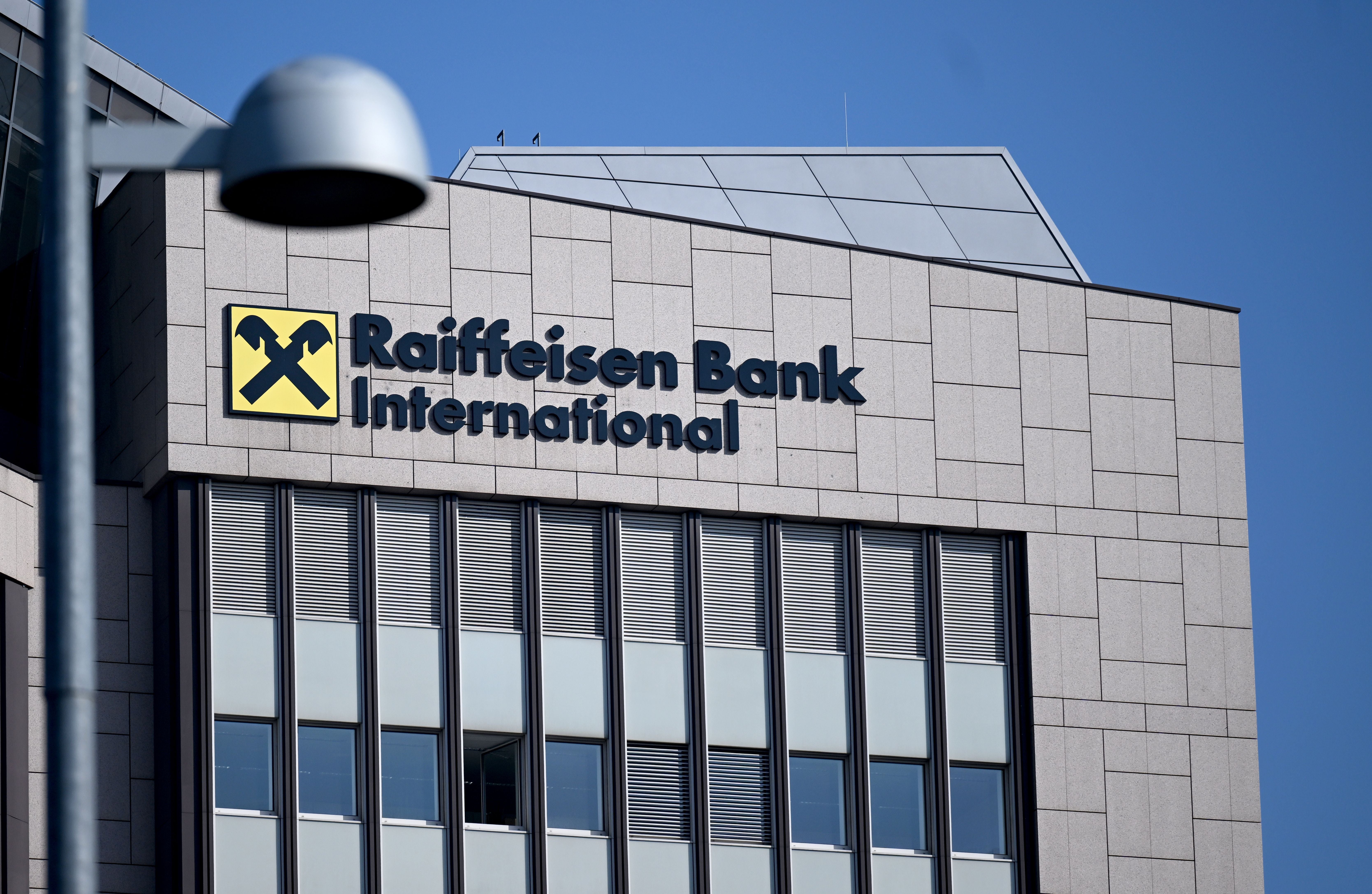 Das Logo der Raiffeisen Bank International am Hauptsitz in Wien vor blauem Himmel.