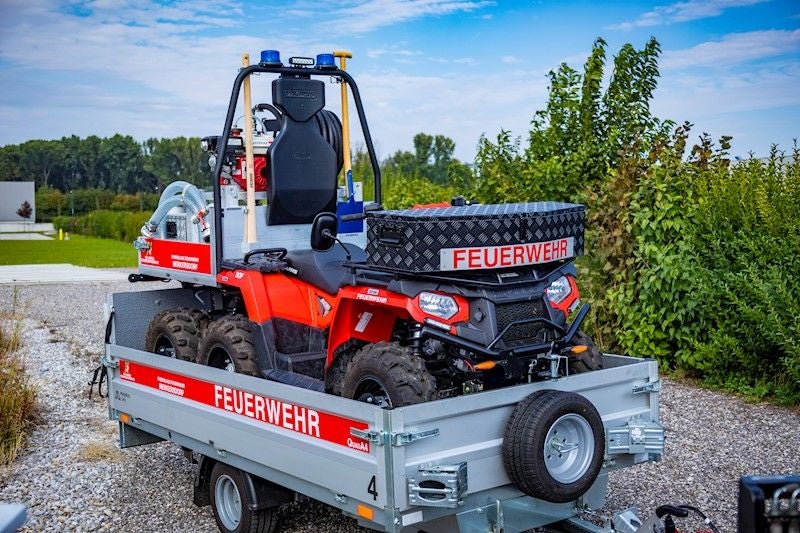 Ein Feuerwehr-Quad zur Waldbrandbekämpfung steht auf einem Anhänger im Freien.