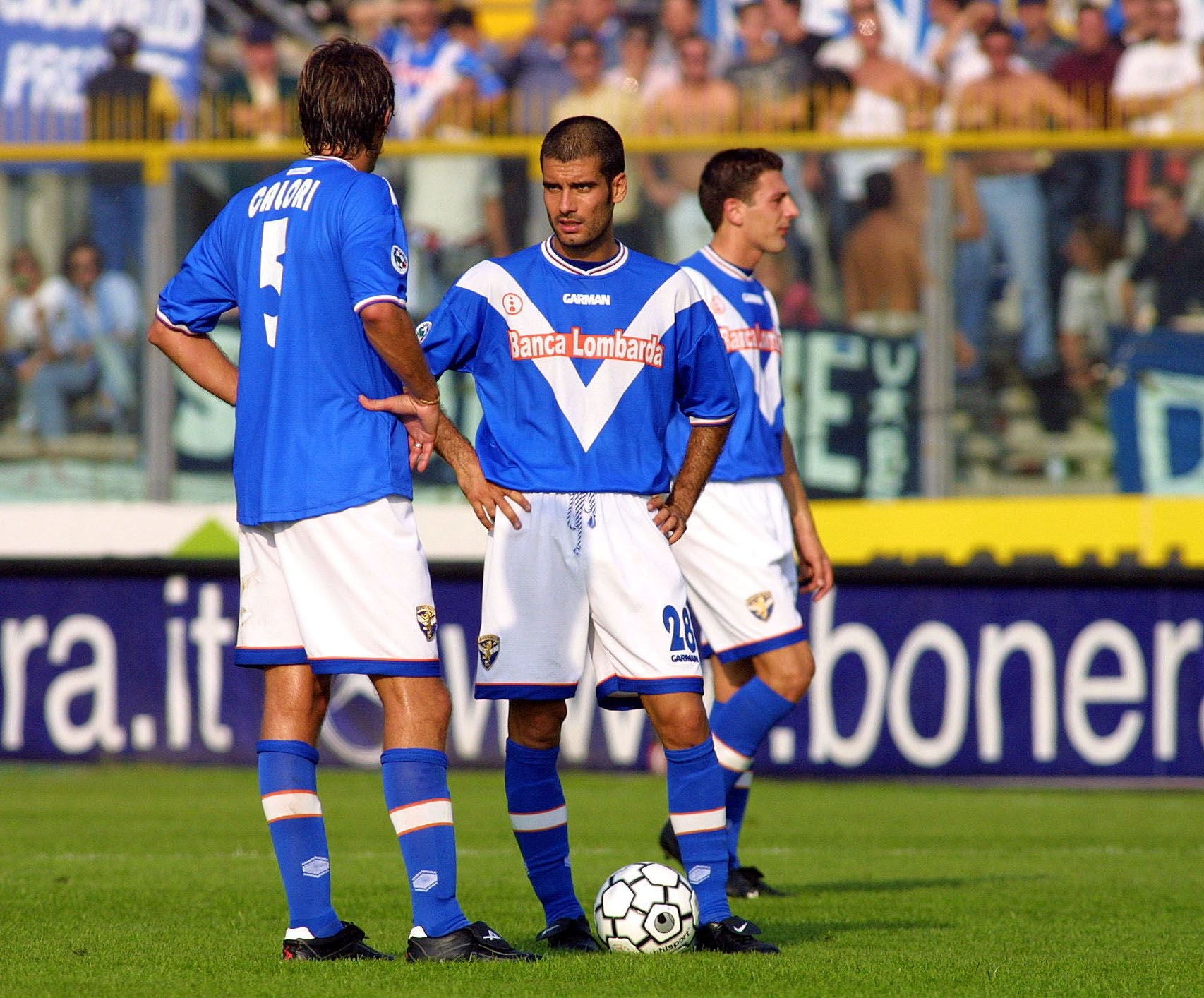 Drei Brescia-Spieler im blauen Trikot bereiten sich auf einen Freistoß vor.