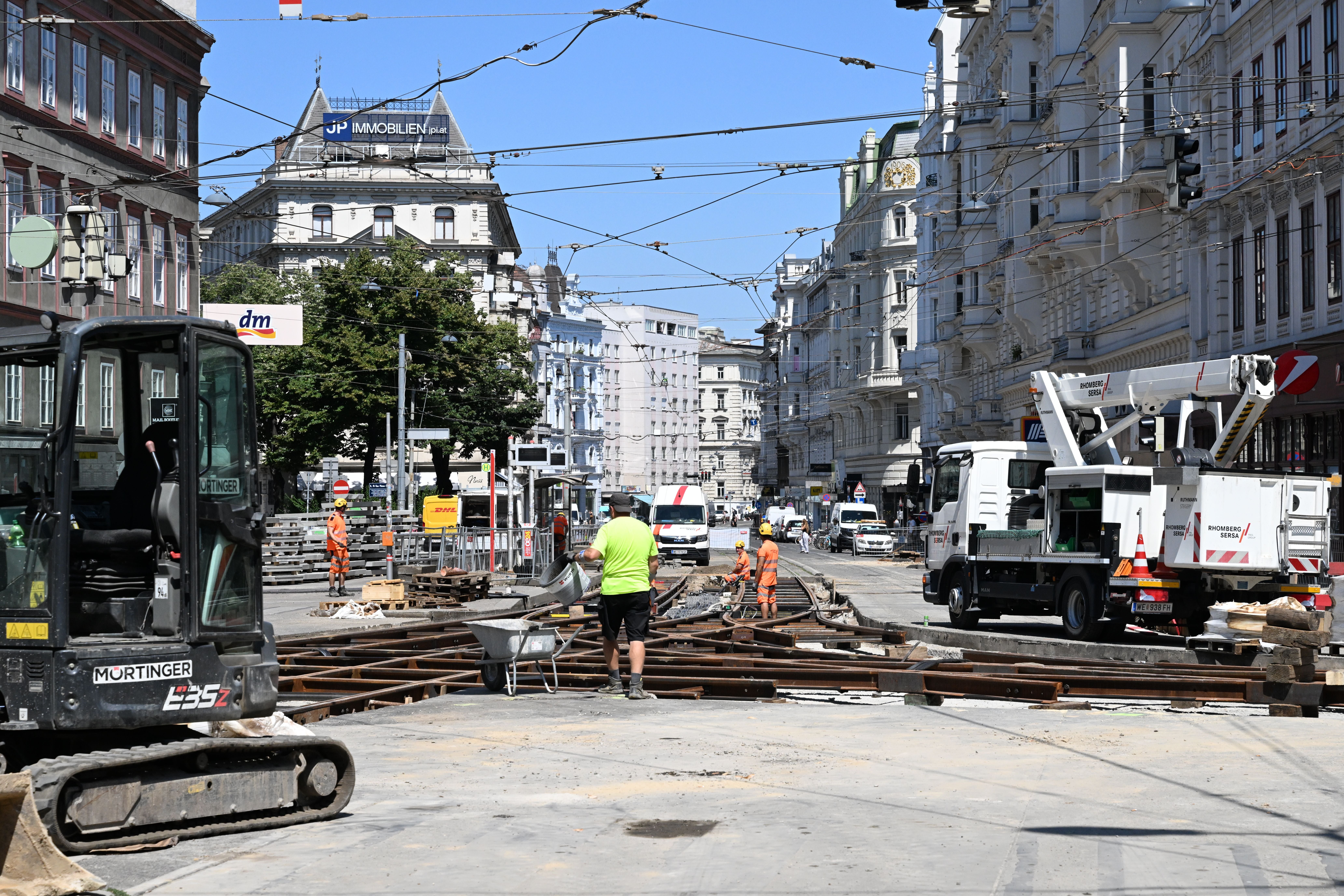 Straßenbaustelle mit Bauarbeitern und Maschinen auf der Währingerstraße in einer Stadt.